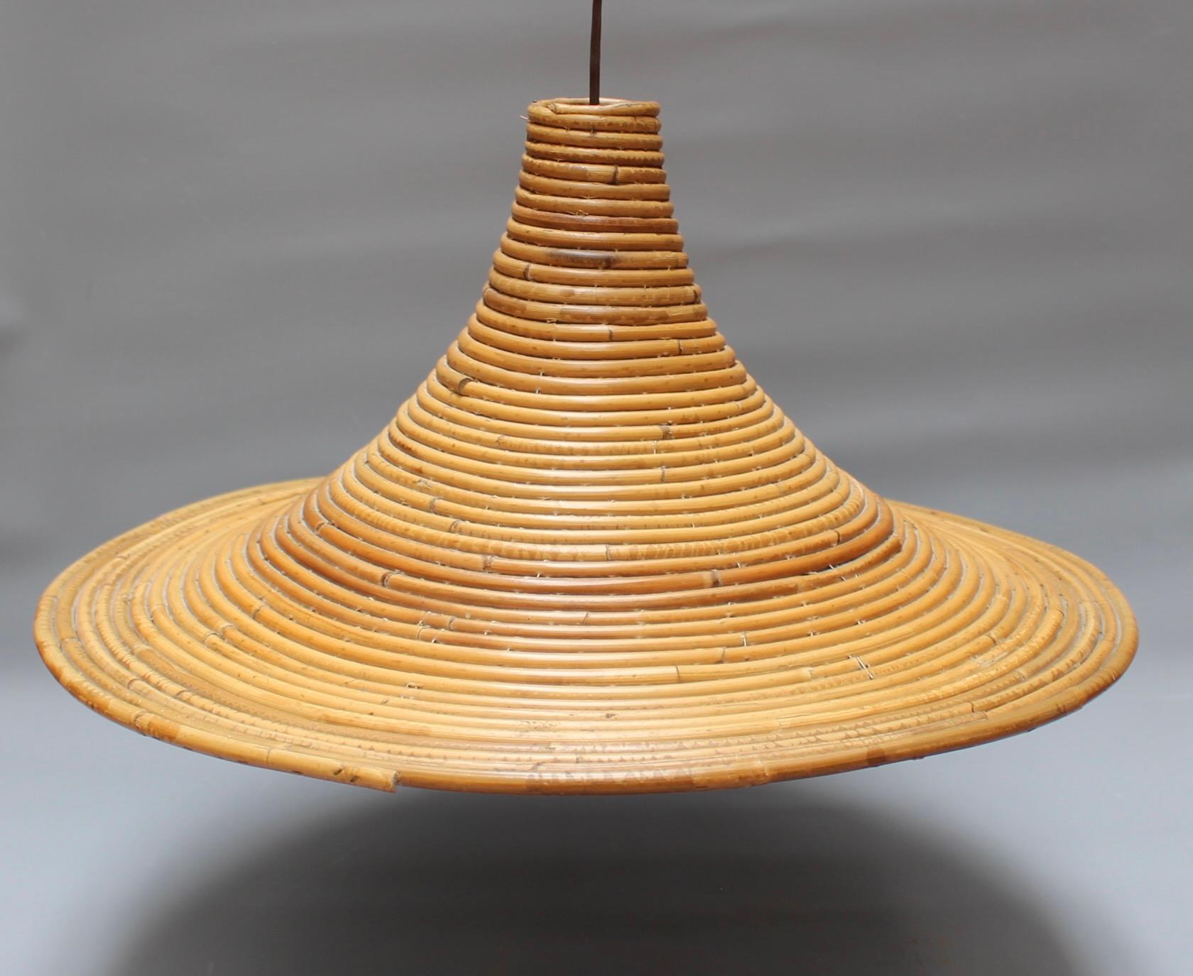 Vintage Italian rattan ceiling pendant lamp (circa 1970s) in the style of Vivai del Sud. Delightfully original, this piece transports you to the Italian Riviera at the height of its glamour. Hanging with its attached rattan chain and ceiling rose,