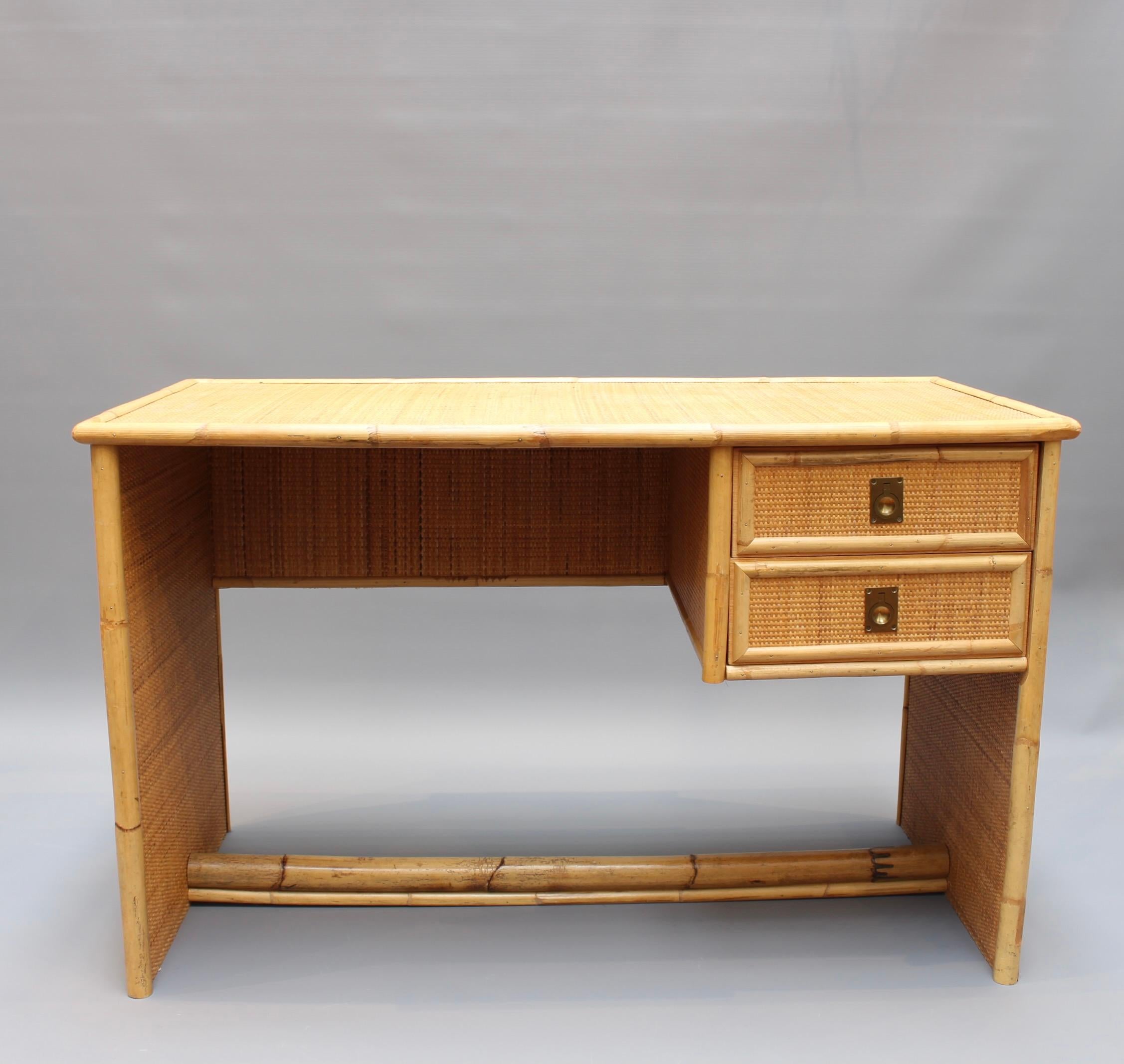 Vintage Italian Rattan desk by well known producer, Dal Vera (circa 1970s). An absolute charmer and an icon of the era. There are two drawers located under the desk with stylish brass ring handles. The sides beautifully patterned in wicker couple