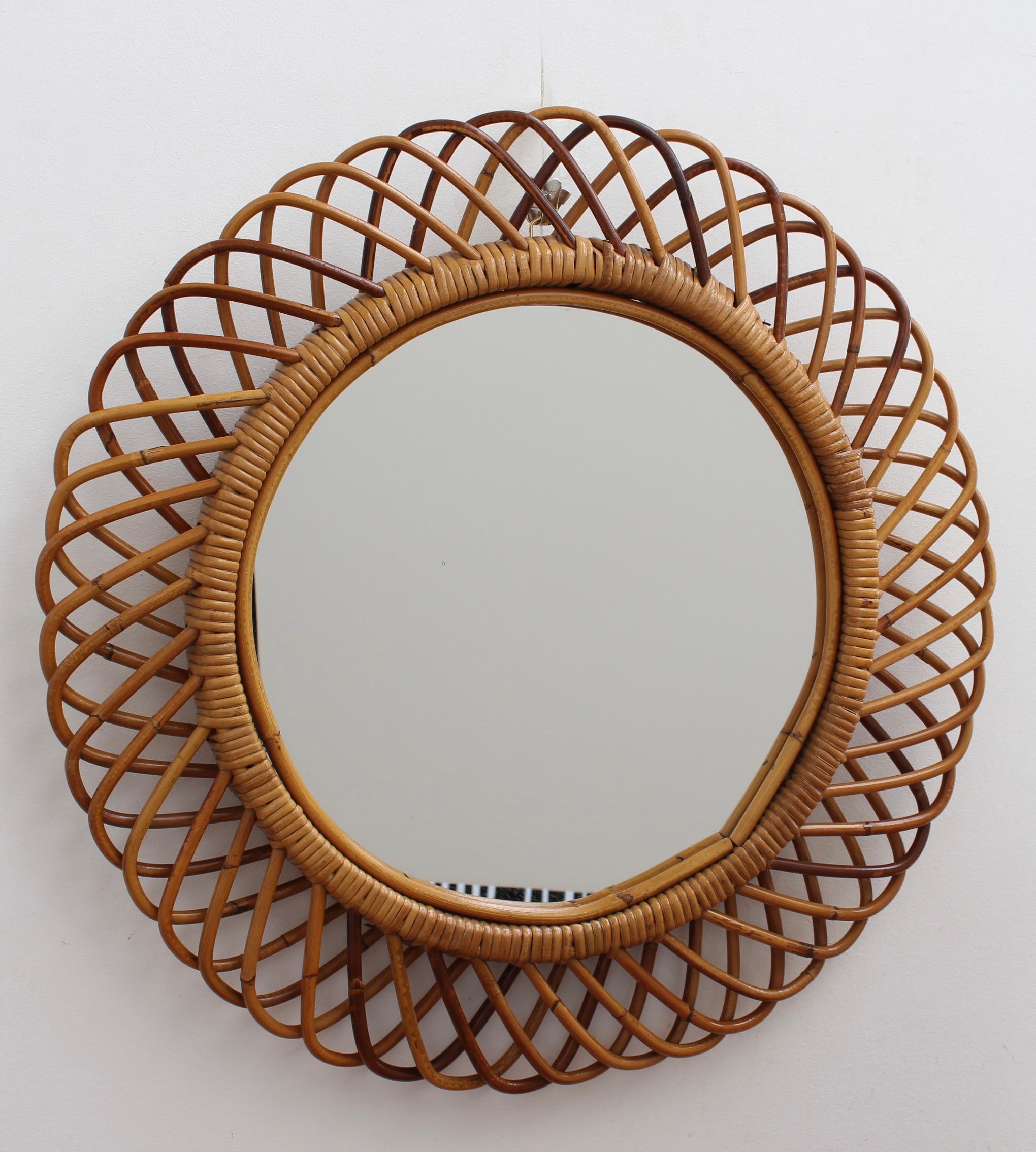 Italian rattan round wall mirror (circa 1960s) in the style of Franco Albini. This is a delightful vintage mirror with substantial depth and a complex weave of rattan. There is a beautiful patina on the rattan and it is in good overall condition.