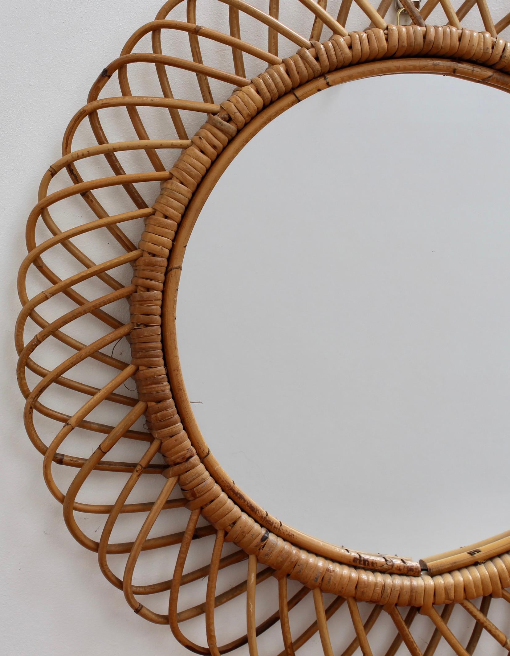 Italian rattan round wall mirror (circa 1960s) in the style of Franco Albini. This is a delightful vintage mirror with a complex weave of rattan. There is a characterful patina on the rattan and it is in good overall condition. The mirror glass is