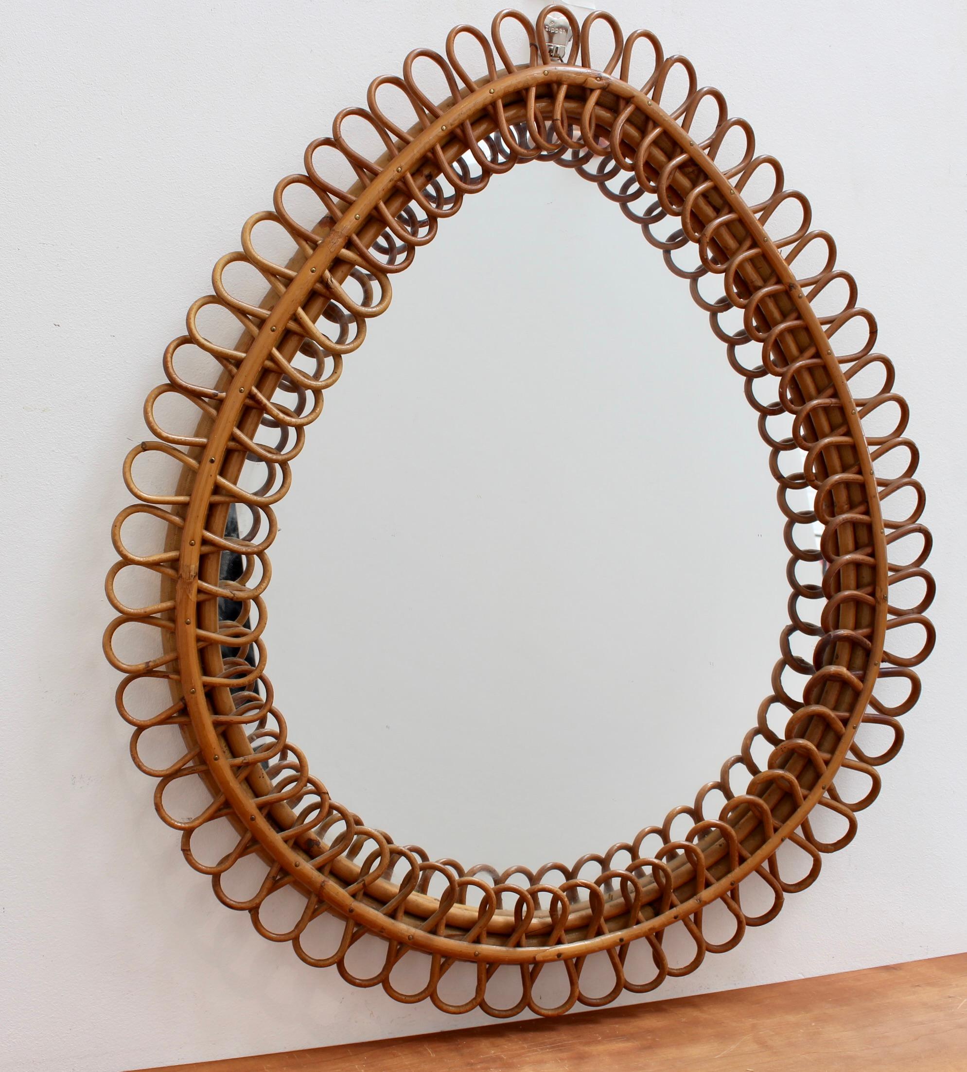 Italian teardrop rattan wall mirror (circa 1960s). This mirror has a rare teardrop form with delightful rattan figure-8 shapes framing the glass. There is a characterful, age-related patina on the rattan frame. In good overall condition commensurate