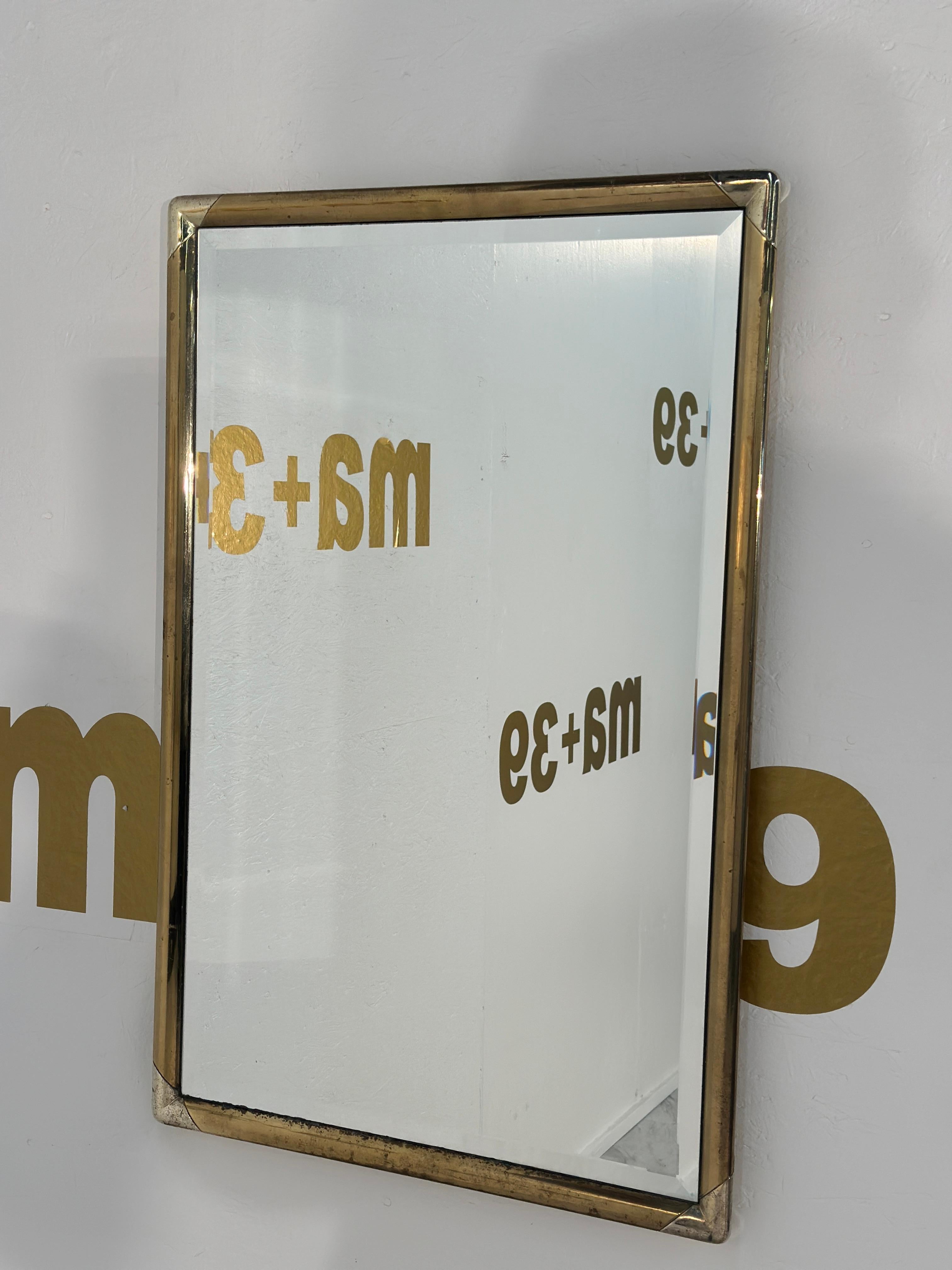 Le miroir mural rectangulaire italien vintage des années 1960 présente un cadre en laiton avec une patine d'origine, mettant en valeur son caractère élégant et vieilli dans un design épuré et intemporel.

