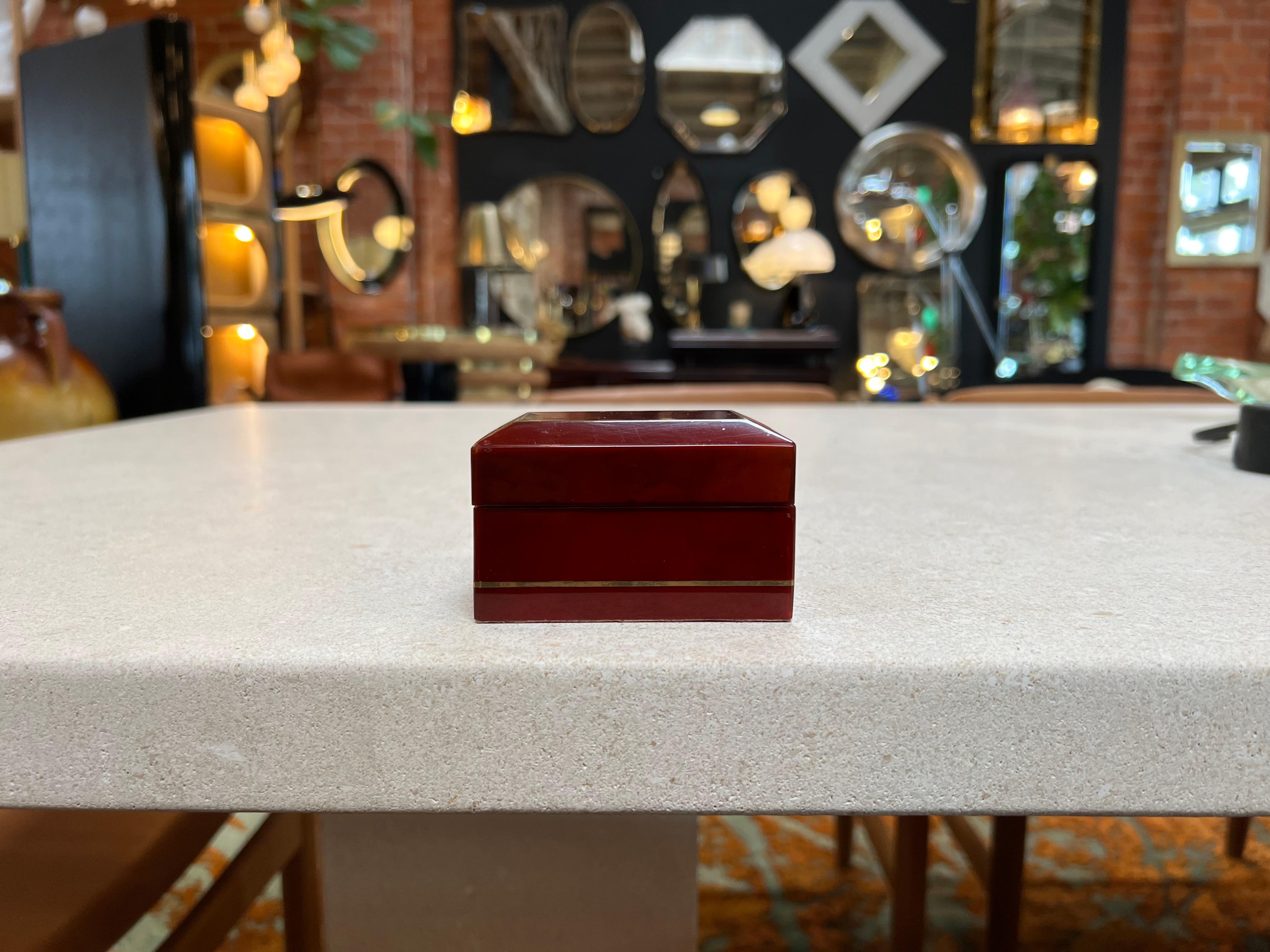 Discover the allure of vintage Italian design with this exquisite Red Decorative Rectangular Box from the 1980s. Meticulously crafted, it showcases a stunning fusion of rich red hues and elegant brass details. This captivating piece serves both as a