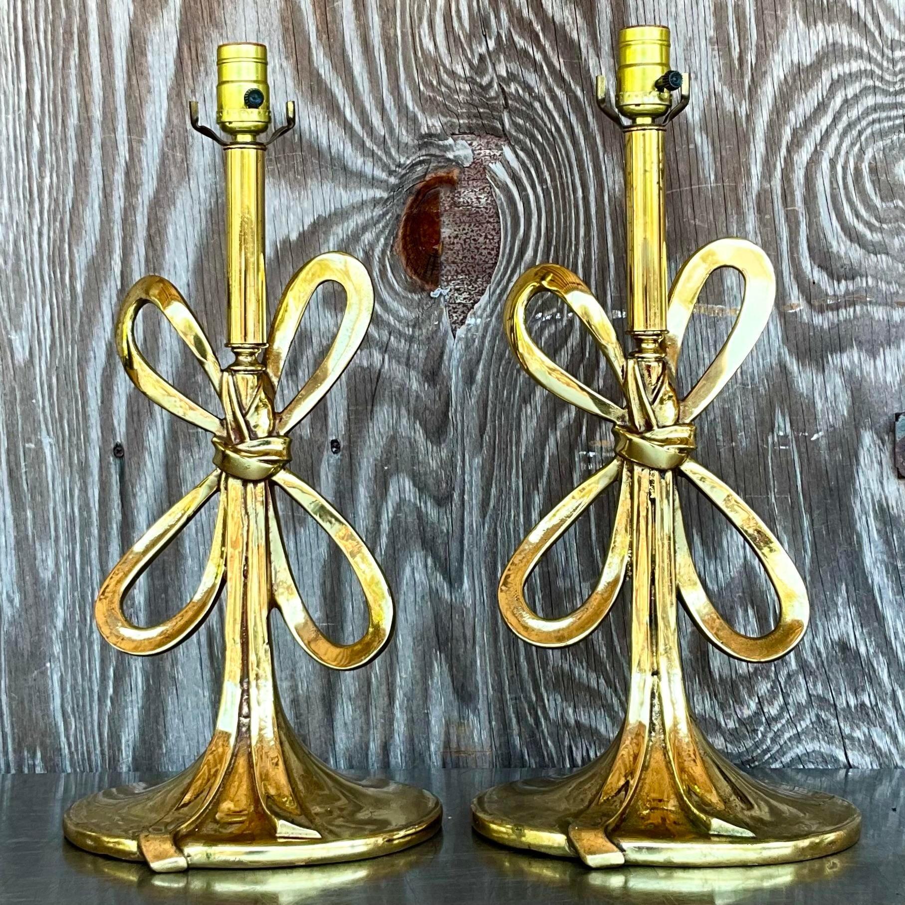 Illuminate your space with our Vintage Italian Regency Polished Brass Bow Lamps. Sold as a pair, these American-curated treasures feature elegant Regency design with polished brass bows, adding a touch of Italian luxury and timeless charm to any
