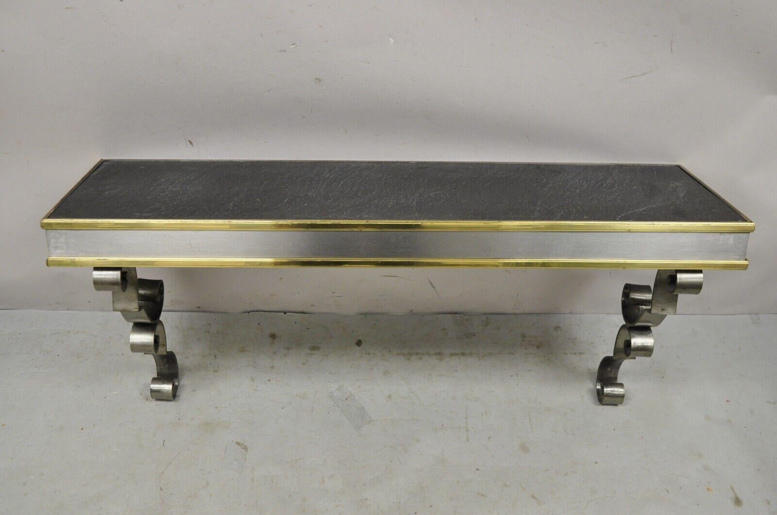 Vintage Italian Regency Steel and Brass Wall Mount Console Table with Slate Top. Les caractéristiques de l'article sont les suivantes : plateau rectangulaire en ardoise, cadre en métal du tabouret, accents en laiton, supports à volutes, très bel