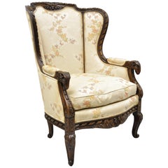 Fauteuil bergère vintage de style Régence italienne à dossier à oreilles en noyer sculpté avec tête de bélier