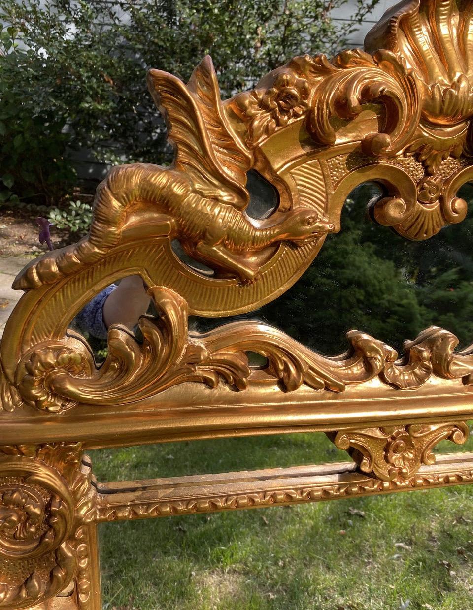 Vintage rare Italian Regency-Style Reproduction Gold Mirror (1960-80s) featuring ornate embellishments and two imposing dragons in flight. Painted and made of heavy composite.
Style is a fusion of European and Asian influences
Material is a wood