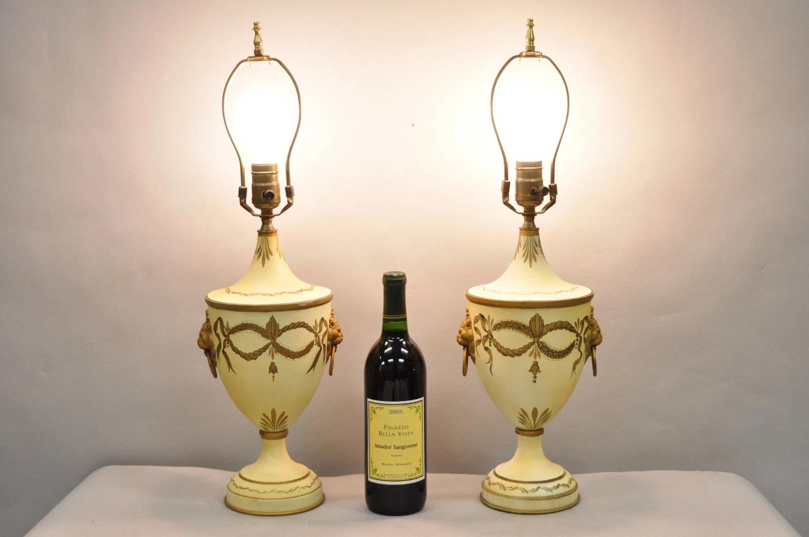 Vintage Italian Regency Style Tole Metal French Country Cream and Gold Urn Table Lamps with Lion Head Drop Handles - a Pair. Circa Mid 20th Century. Dimensions : 23,5