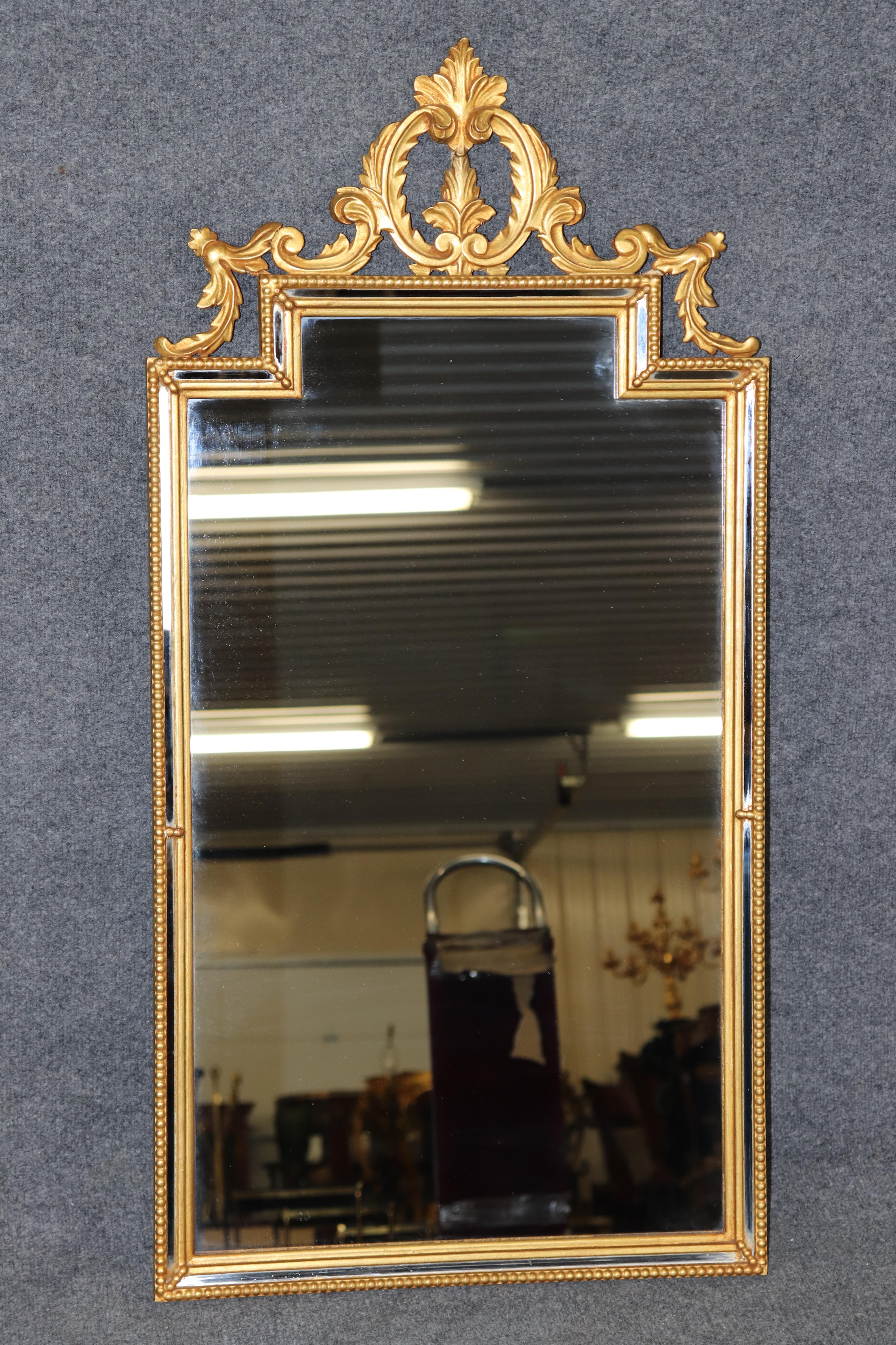 Dimensions - H : 43 3/4 in W : 22 po D : 1 1/4 po 

Ajoutez un charme opulent à votre intérieur avec ce superbe miroir doré sculpté de style rococo italien, datant des années 1950. Cette pièce exceptionnelle témoigne de l'attrait durable du design