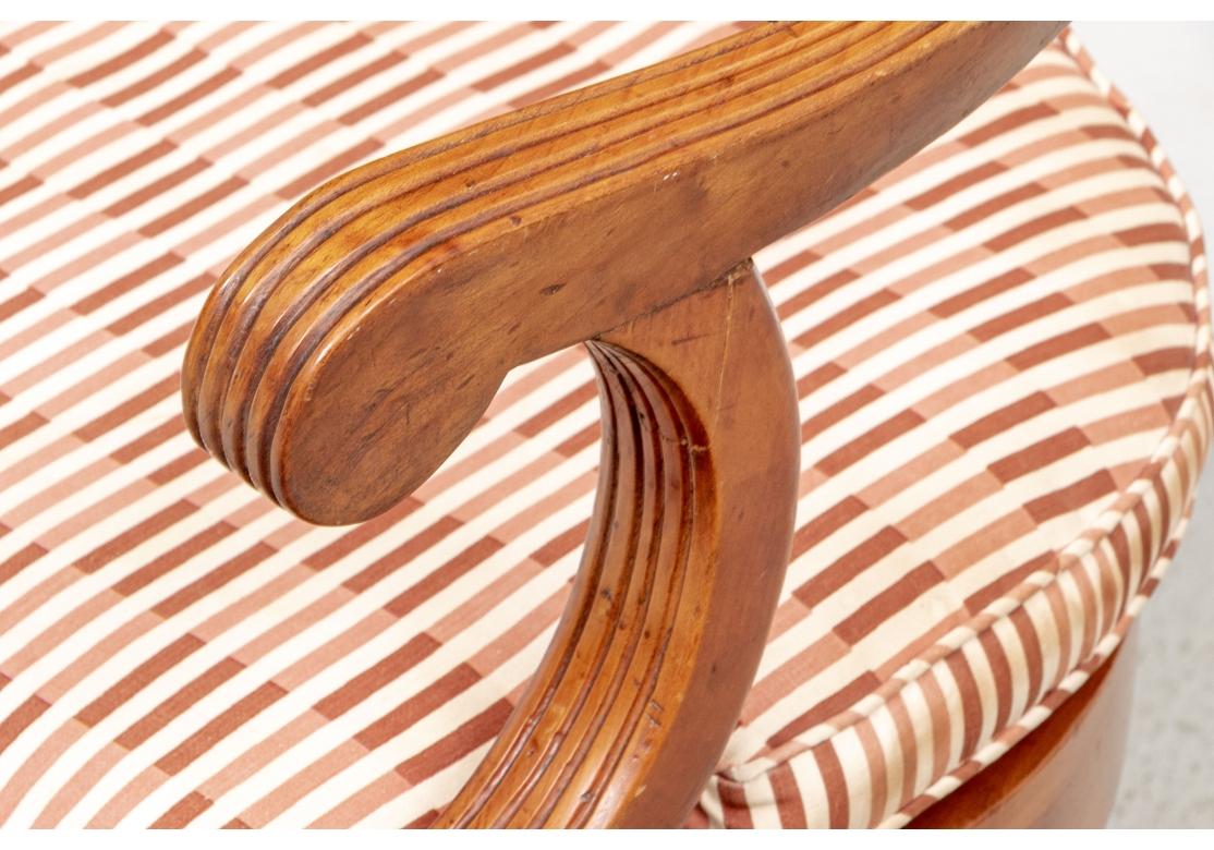 Ca. 1960's. Ein fein geschnitzter römischer Sessel im Regency-Stil mit einem Rahmen aus geriffeltem Olivenholz. Die eleganten schrägen Arme mit geschwungenen Enden und geschwungenen Stützen. Der handgezogene Sitz aus Schilfrohr hat ein separates,