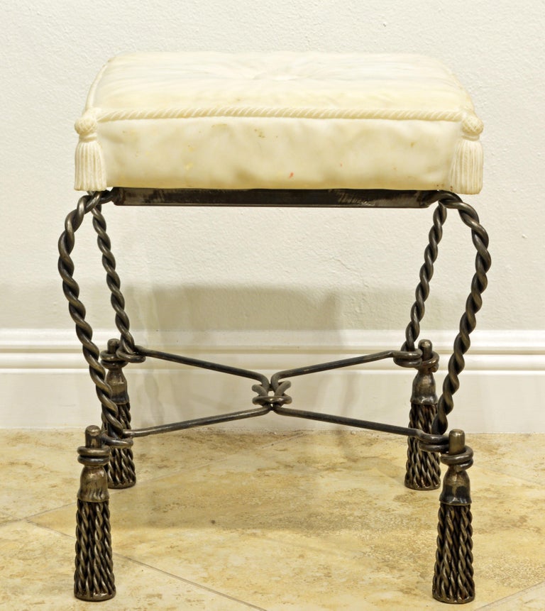 The seat carved as a cushion in Carrara marble makes this Italian bench or stool quite unique. The seat is supported by a frame fashioned as twisted rope and large intricately braided tassels serve as feet. The marble seat comes apart from the seat