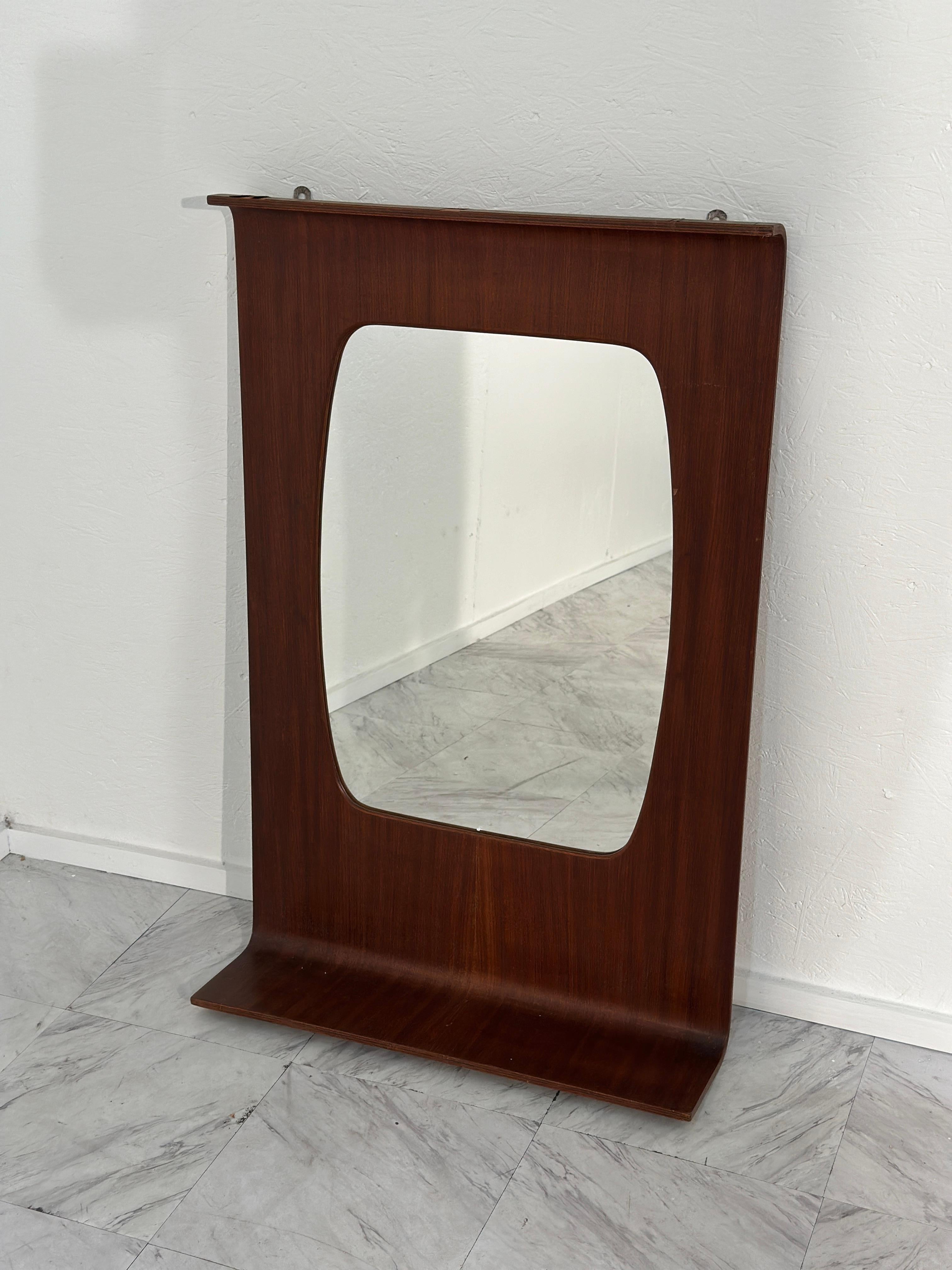 This Vintage Italian Rosewood Veneer Plywood Mirror from the 1960s exudes timeless elegance and Italian craftsmanship. The rosewood veneer plywood frame adds warmth and sophistication to any space, while the addition of a lower shelf provides both