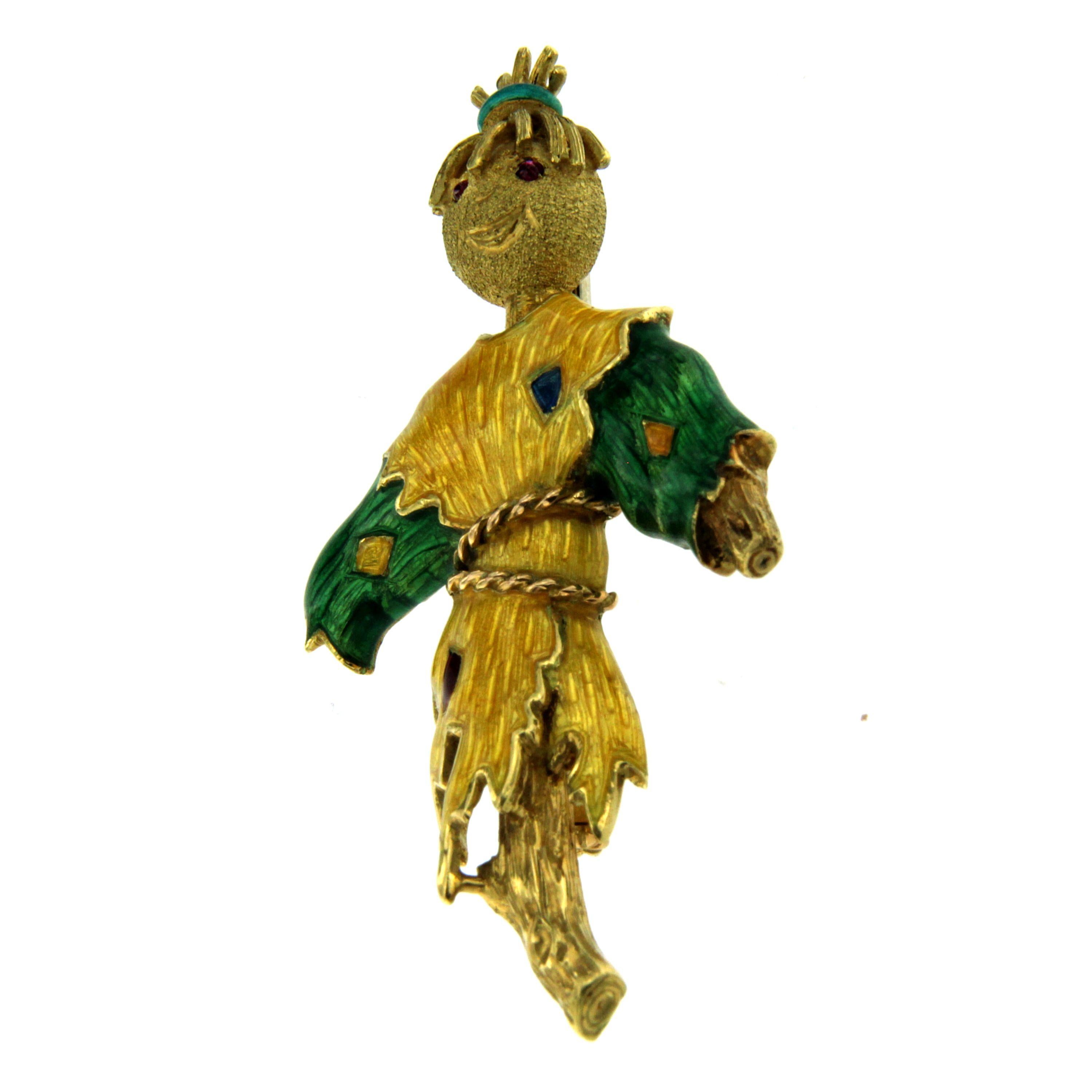 Scarecrow brooch in costume enameled on 18K yellow gold and adorned by ruby and sapphire.
The brooch is stamped with creator marker's mark and a hallmark for 18 karat gold.

This unusual piece is designed and crafted entirely by hand in the