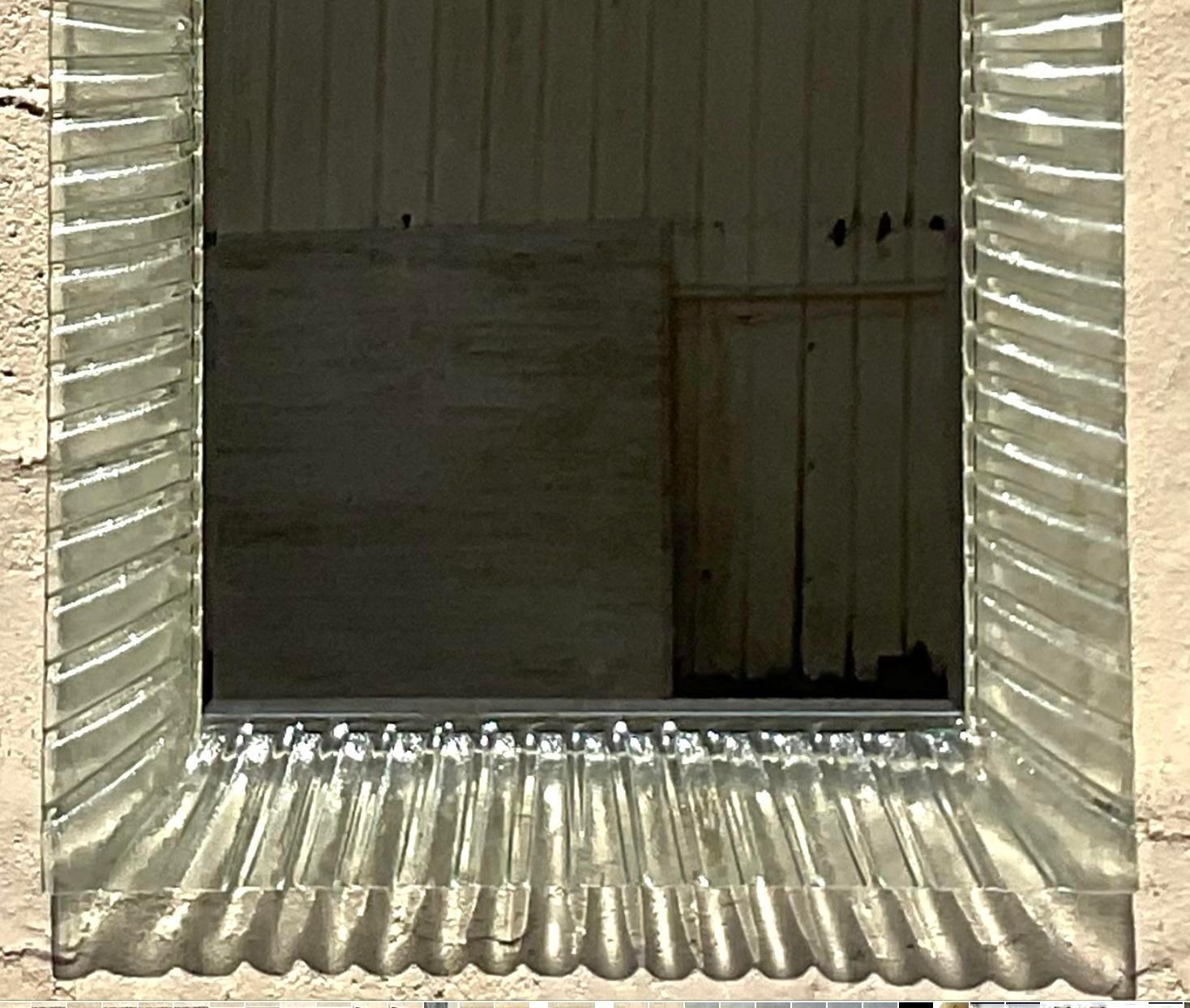 Illuminate your space with the Vintage Italian Ruffle Glass Mirror After Murano. Featuring an elegant ruffle glass frame inspired by Murano craftsmanship, this mirror adds a touch of Italian sophistication and vintage charm to any room. Perfect for