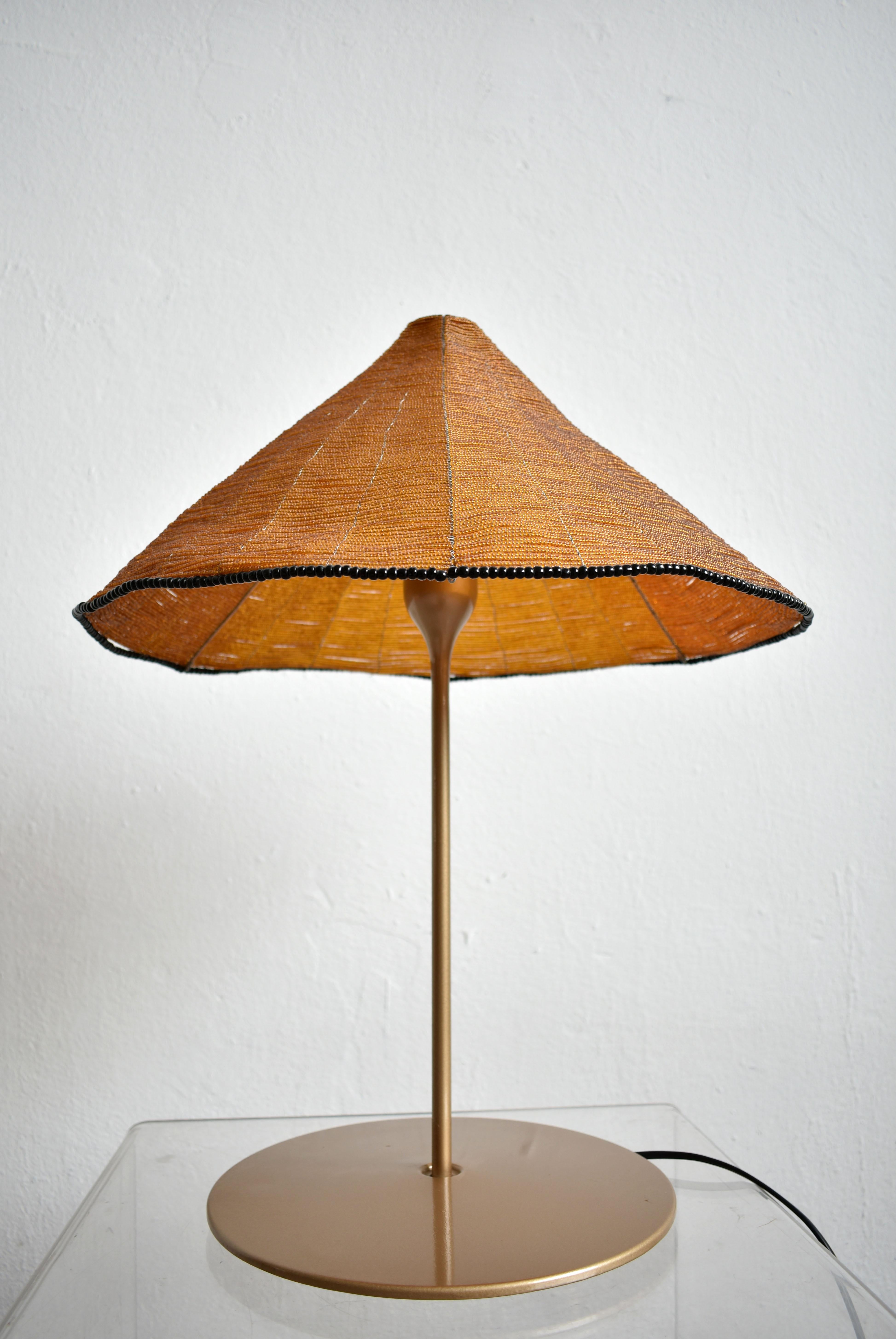Rara lampada da tavolo di design italiano 'Sarasar T', disegnata da Renato Toso e Roberto Pamio e prodotta da Leucos negli anni '80 e '90.

La lampada è dotata di un diffusore in vetro a forma di parasole composto da migliaia di piccole perle di