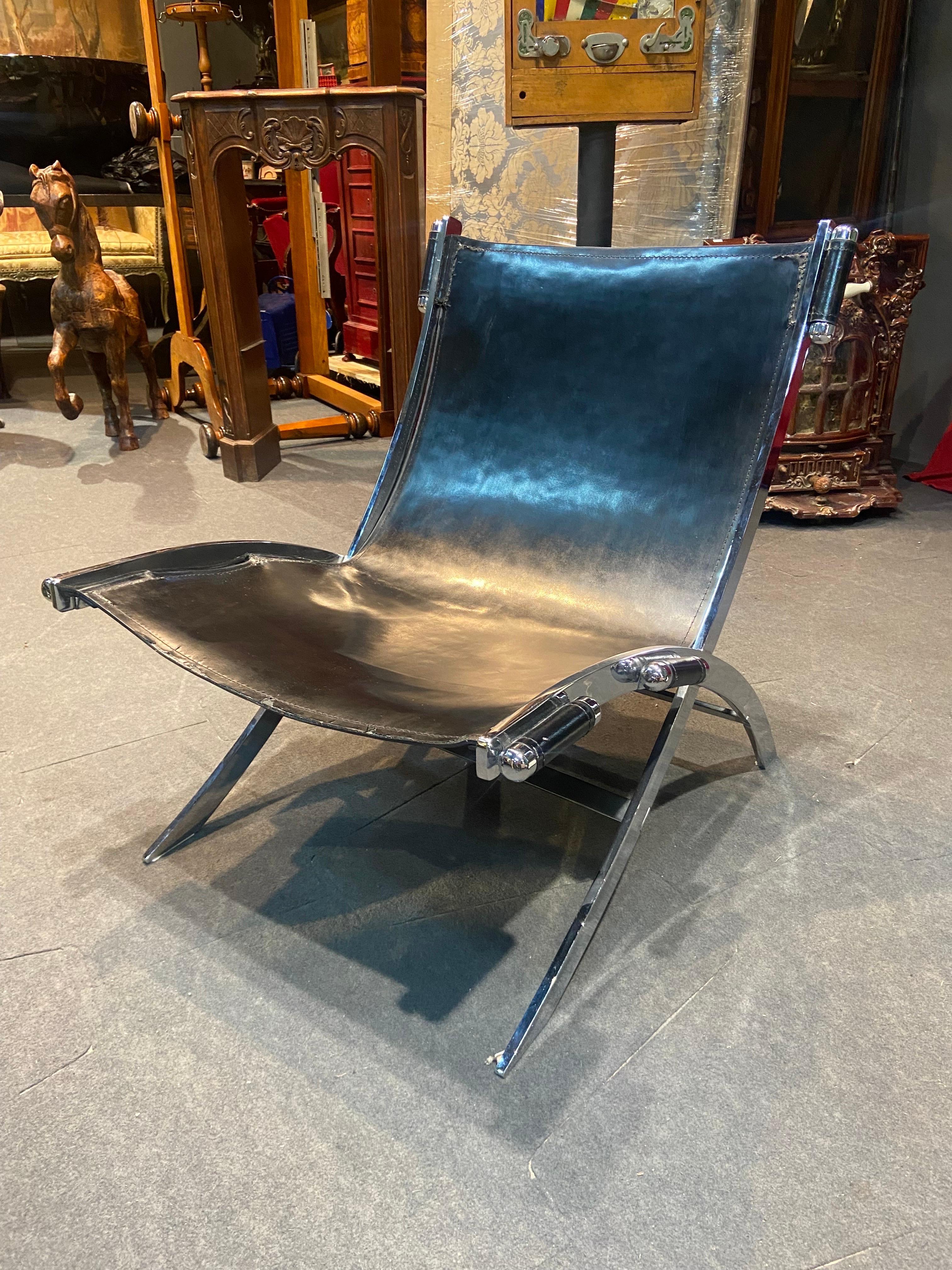 Italian post-modern scissor chair in stainless steel and black leather by Antonio Citterio for Flexform. The thick leather is stretched within the frame and held in place by six chrome cylinder shaped capsules. The leather shows some damage, as