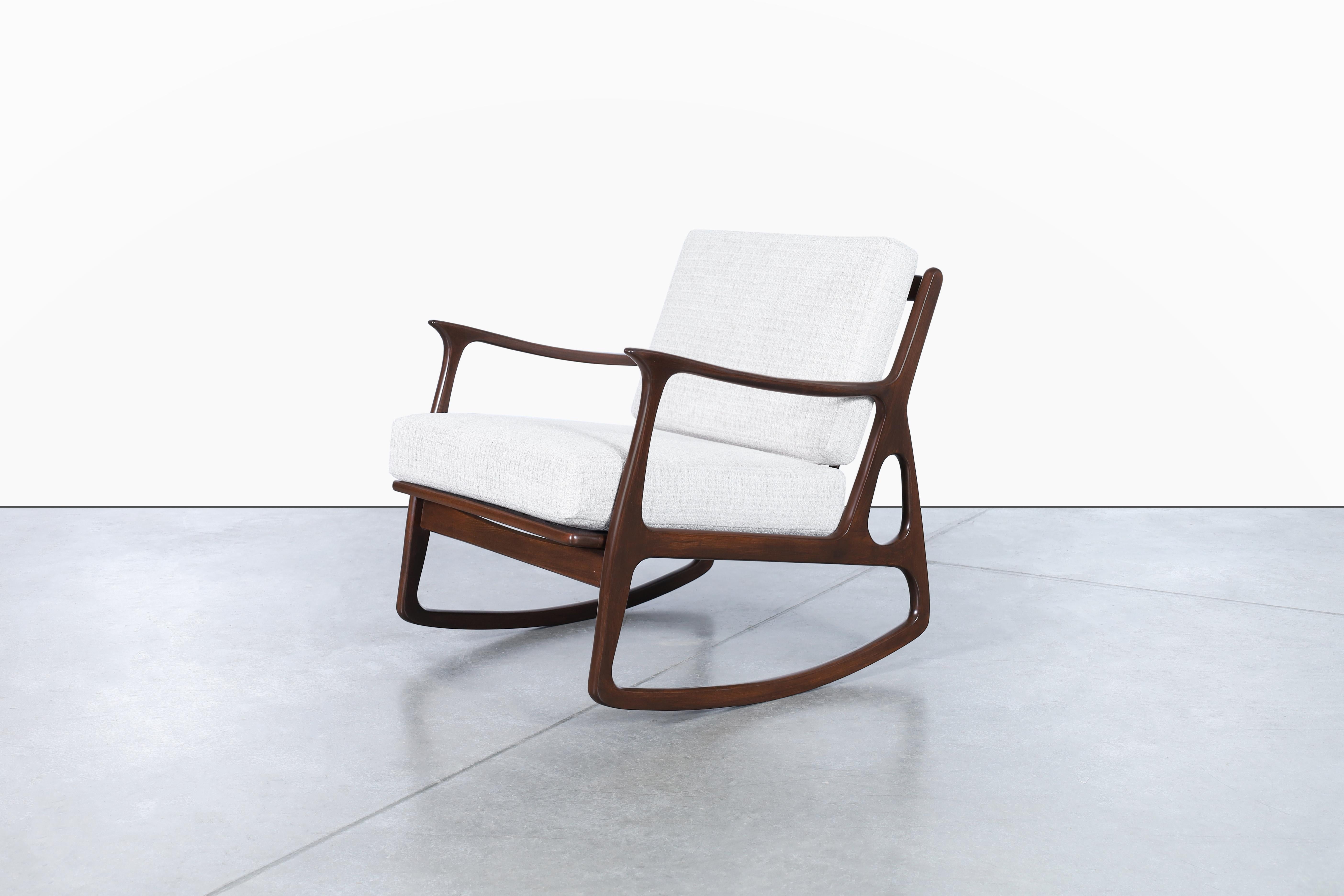 This vintage Italian sculptural rocking chair is a true work of art. Handcrafted with a walnut frame, it boasts a stunning sculptural design that is both elegant and unique. The chair has been beautifully refinished and reupholstered with a thick