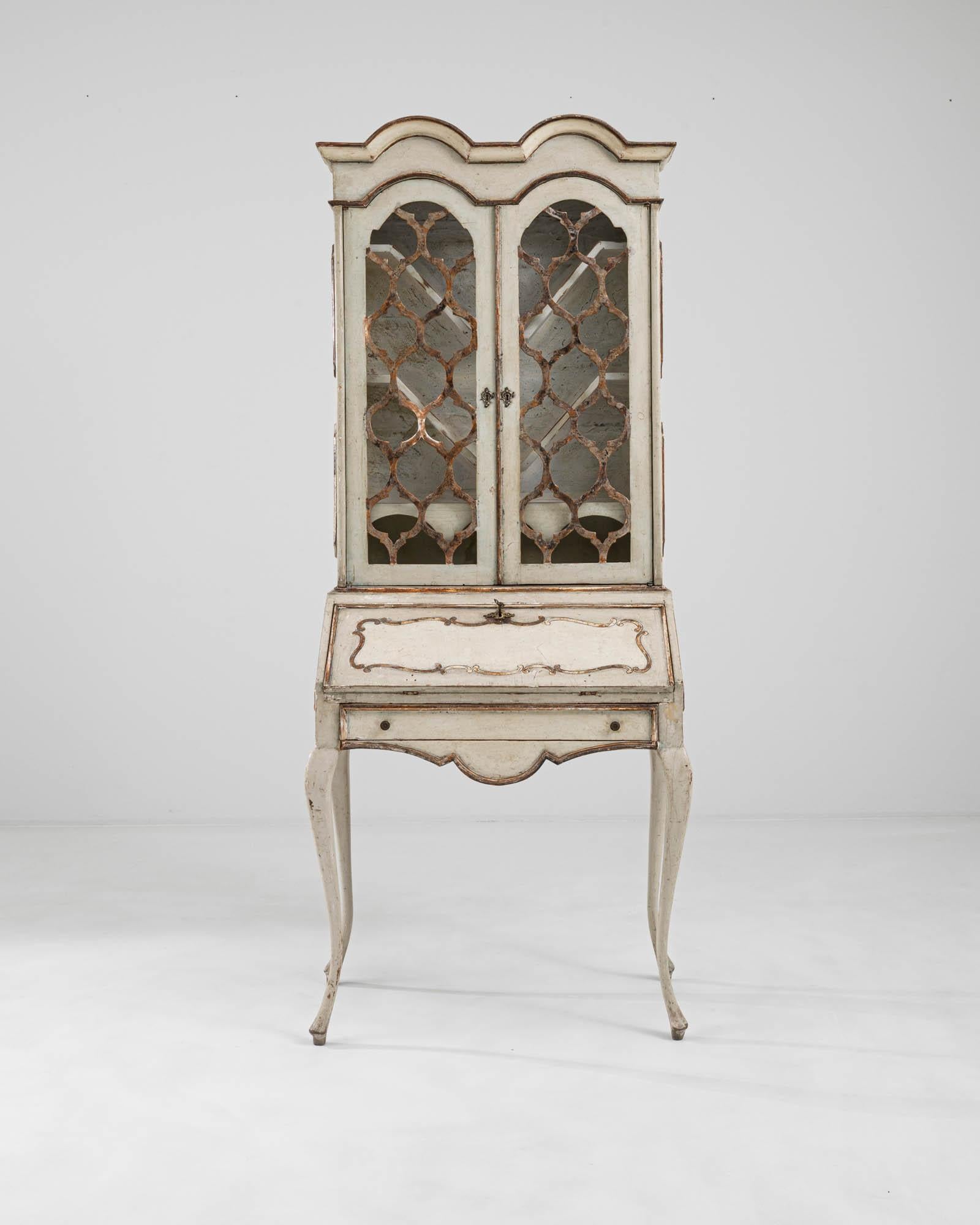 A wooden vitrine created in 20th century Italy. A true treasure, this exquisitely shaped vitrine is characterized by mesmerizing patterning, elegantly shaped legs and a subtle yet striking color palette. Curiously shaped display shelves