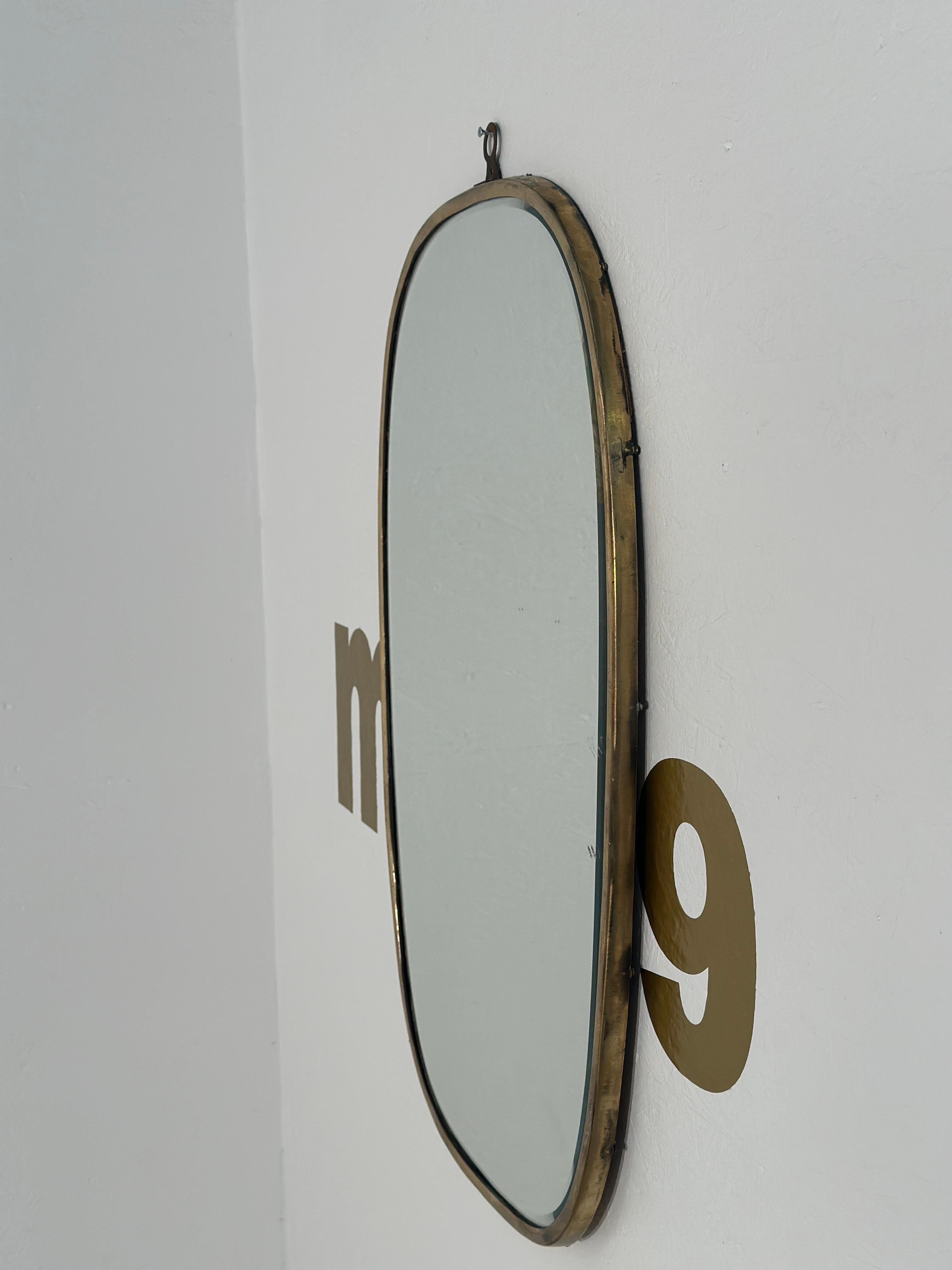 A Vintage Italian Semi-Oval Wall Mirror from the 1970s boasts a sleek and stylish design, featuring a semi-oval shape that captures the essence of Italian sophistication and craftsmanship prevalent during that era.

