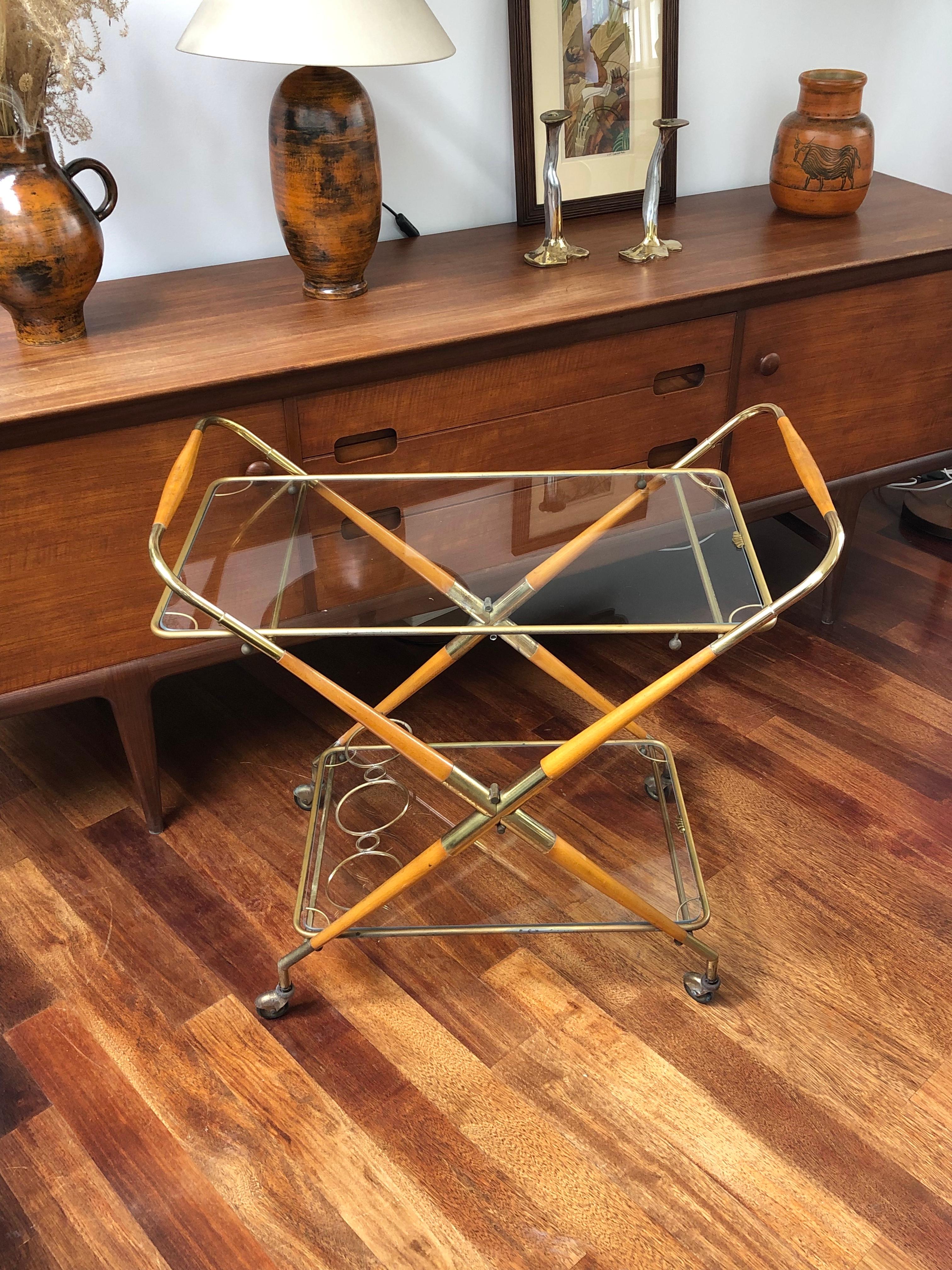 Vintage Italian serving trolley or bar cart (circa 1950s) – midcentury chic, modern style and pure elegance in wood, brass and glass. Wheel your drinks and snacks out in style on this elegantly attractive piece of design history. The two horizontal