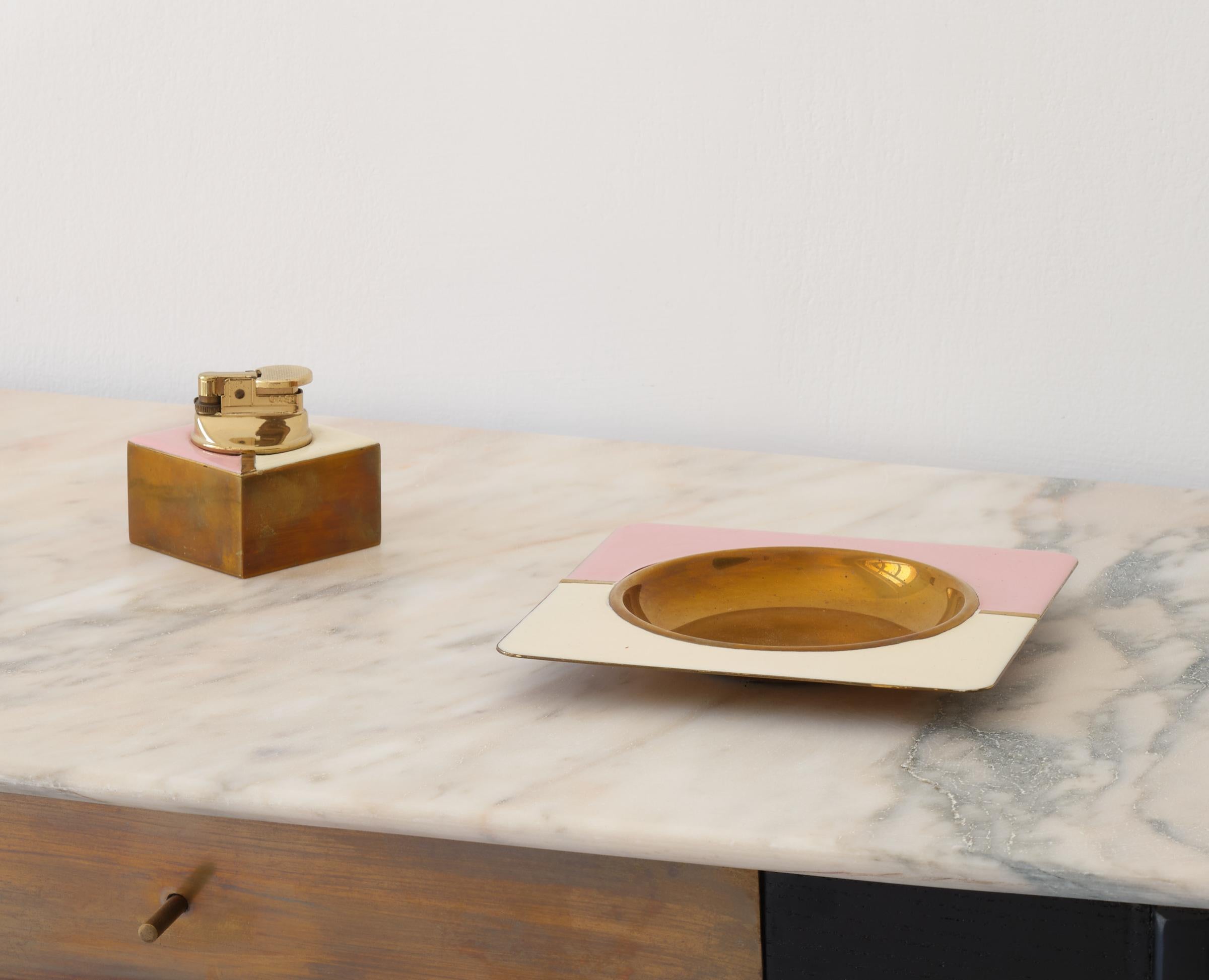 An elegant set consisting of a lighter and ashtray or brass tray, vintage from the 1960s.

Beautiful patina of gilded brass, original cream and strawberry colored enamel in perfect condition.

Ahtray dimensions: 
Height: 2 cm
Width: 15 cm