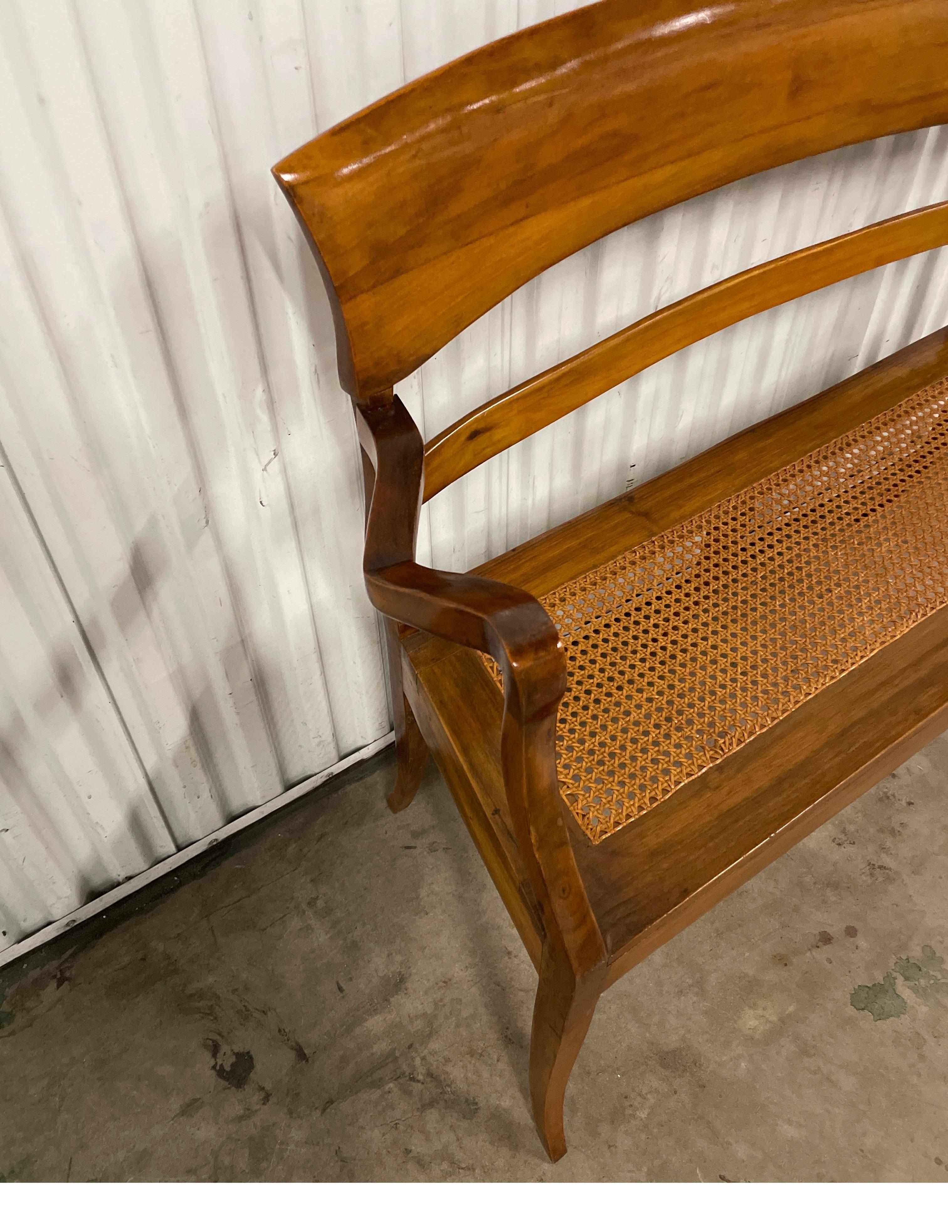Handsome walnut and hand caned seat settee.  Perfect piece for an entryway. Use as is or add your own seat cushion.