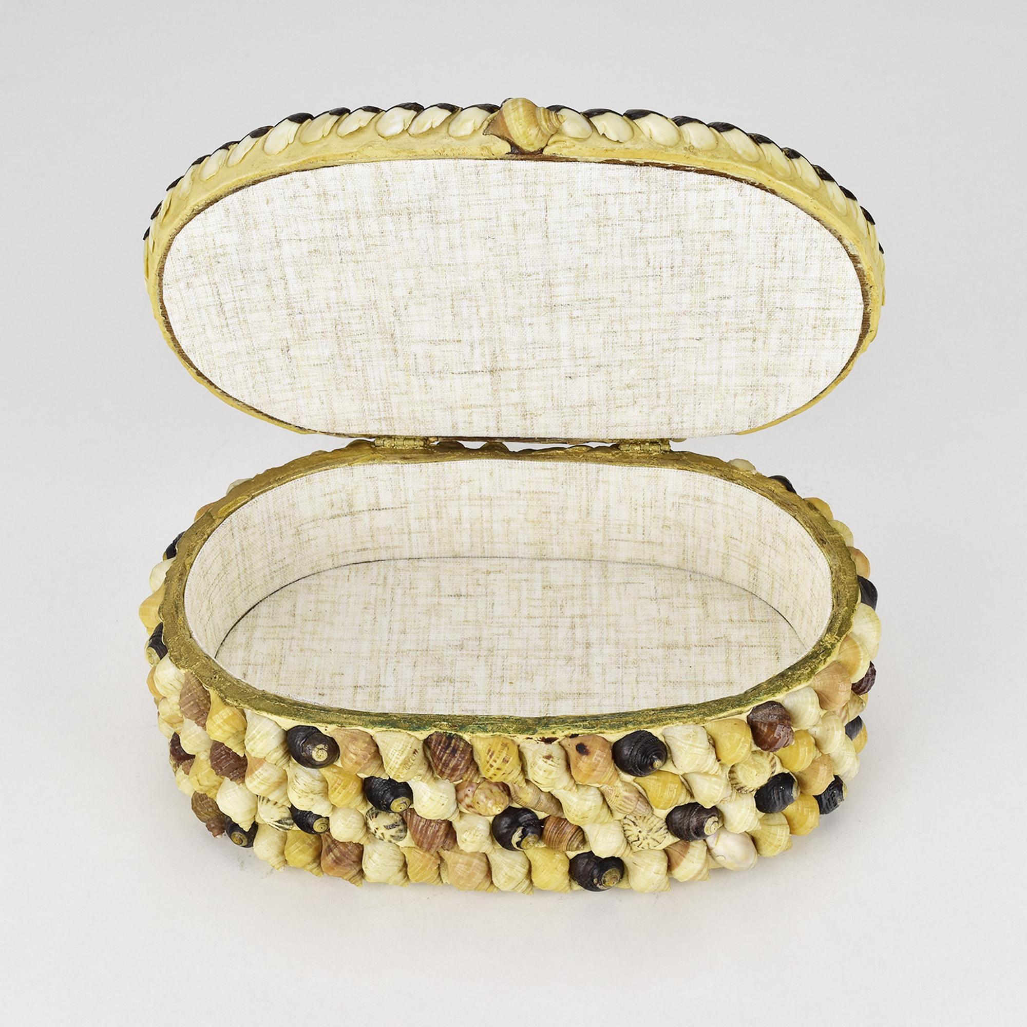 Cette boîte à bijoux italienne finement travaillée et incrustée de coquillages dégage un charmant style Grotto, typique de l'art décoratif du milieu du siècle dernier, dans les années 1950. Sa forme ovale est méticuleusement ornée d'un ensemble de