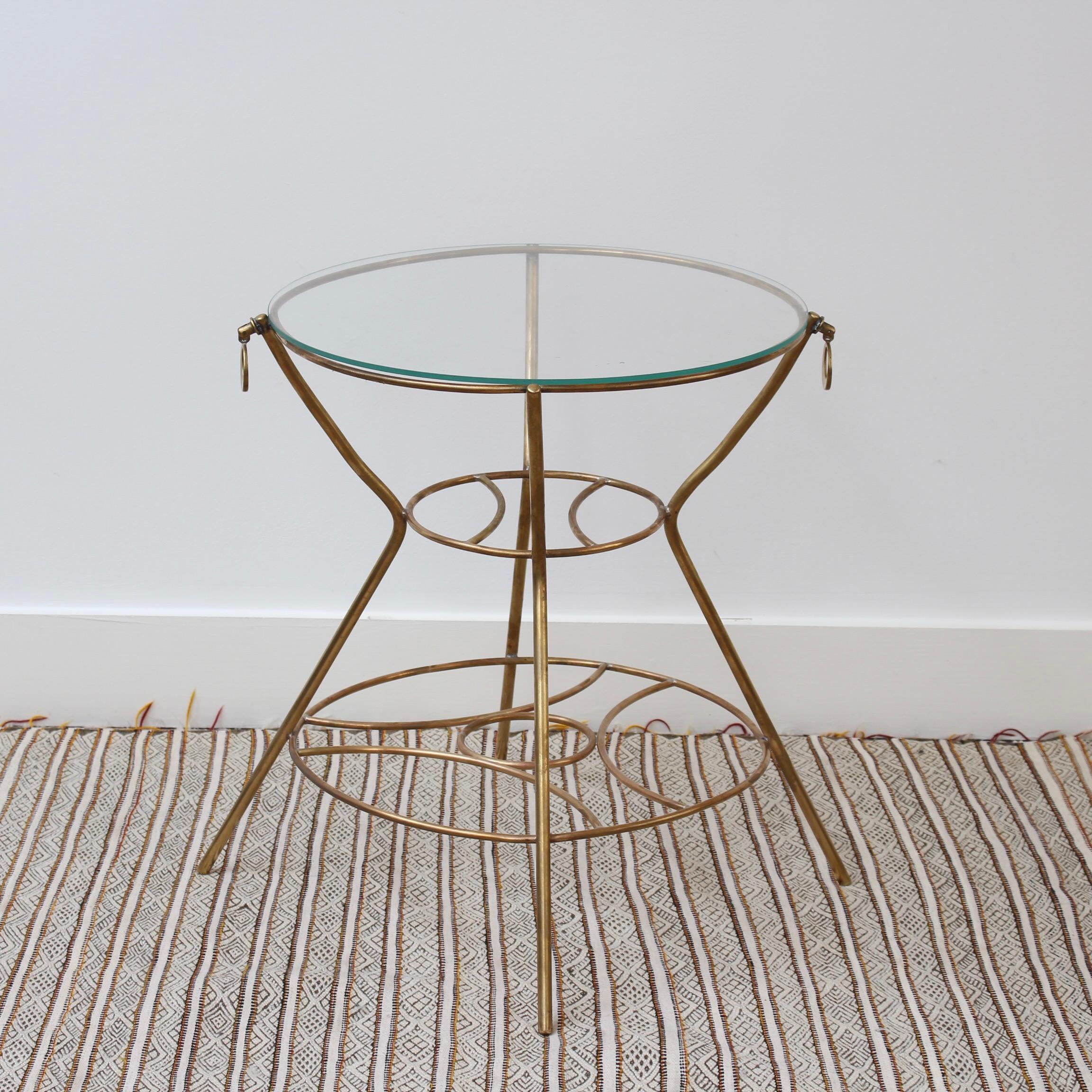 Vintage Italian side table (circa 1960s). Immensely stylish in the modern Italian way, this seductive side table exudes balance, precision and strength. Consisting of three central circles - two in brass and one in glass - the table is supported by