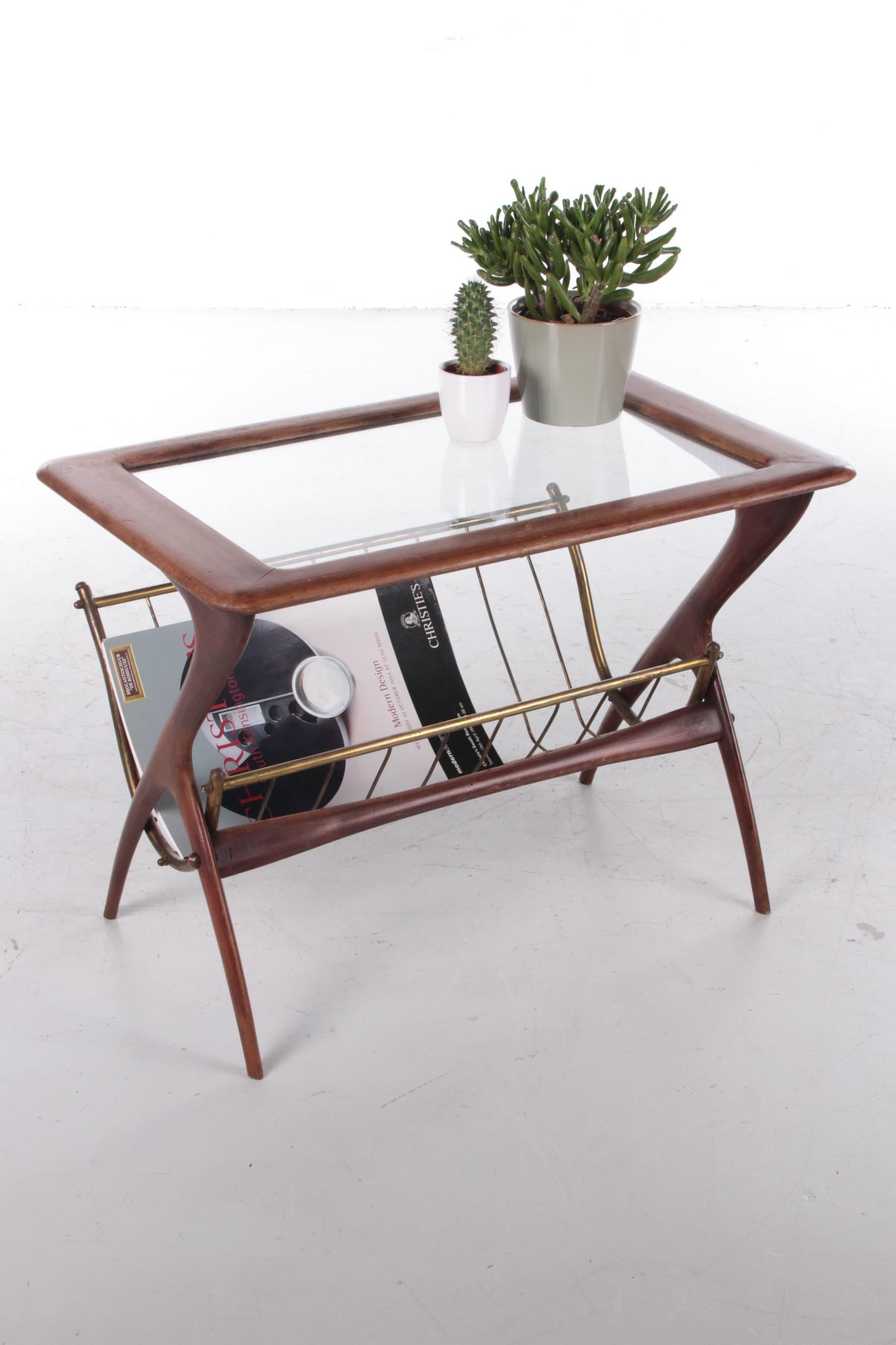 This is a beautiful design by the Italian designer Ico Parisi, produced in Italy around the 1960s.

It is made of lacquered mahogany wood with a beautiful deep brown color, with brass in the frame of the magazine rack. It has a clear inlaid glass