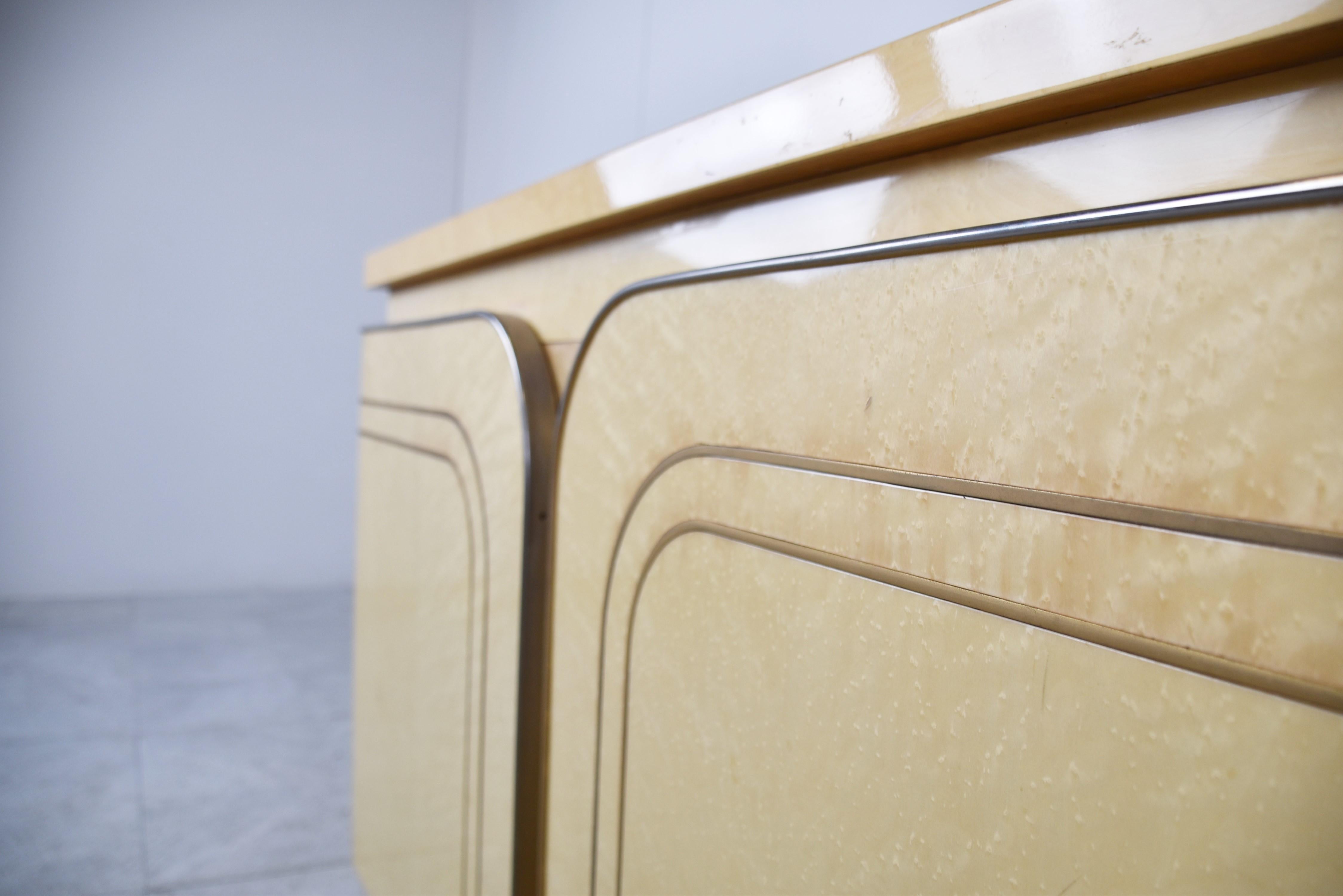 Beautiful wooden and inlaid brass sideboard.

This seventies glam sideboard looks fantastic thanks to the inlaid brass and light coloured wood.

It offer plenty of storage space behind the unusual doors.

1970s - Italy

Good overall