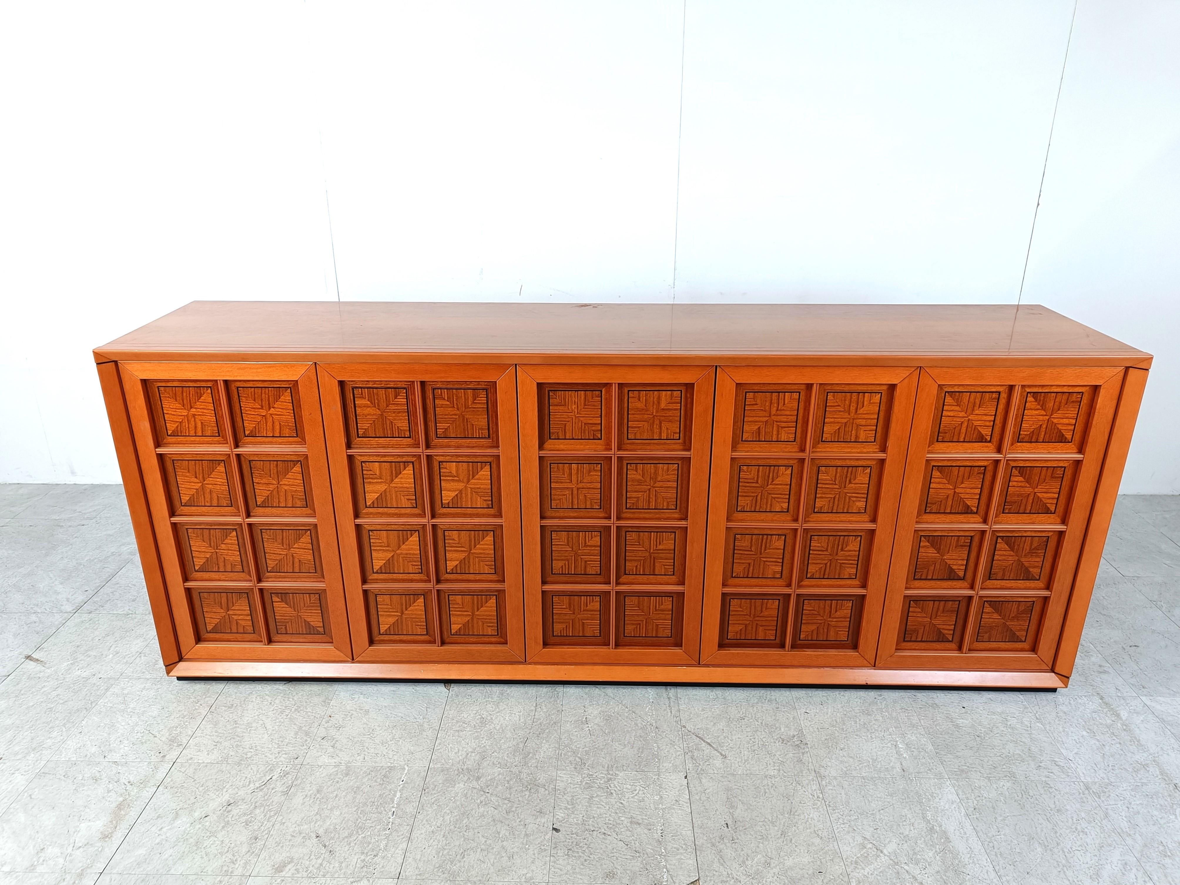 
Gorgeous italian brutalist sideboard with 5 graphical doors with inlaid wood and fine black lines.

The sideboard has a beautiful colour and natural wood vains.

The sideboard also has two integrated drawers.

Very good condition

1970s -