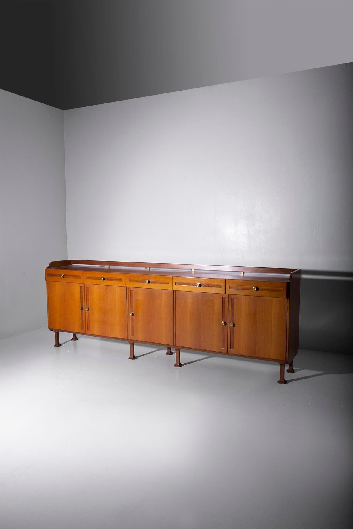 In the world of vintage furniture, there exists a magnificent Italian sideboard, a true treasure from the 1950s, bearing the prestigious label of Mobili di Cantù. This sideboard is not merely a piece of furniture; it is a piece of history, a
