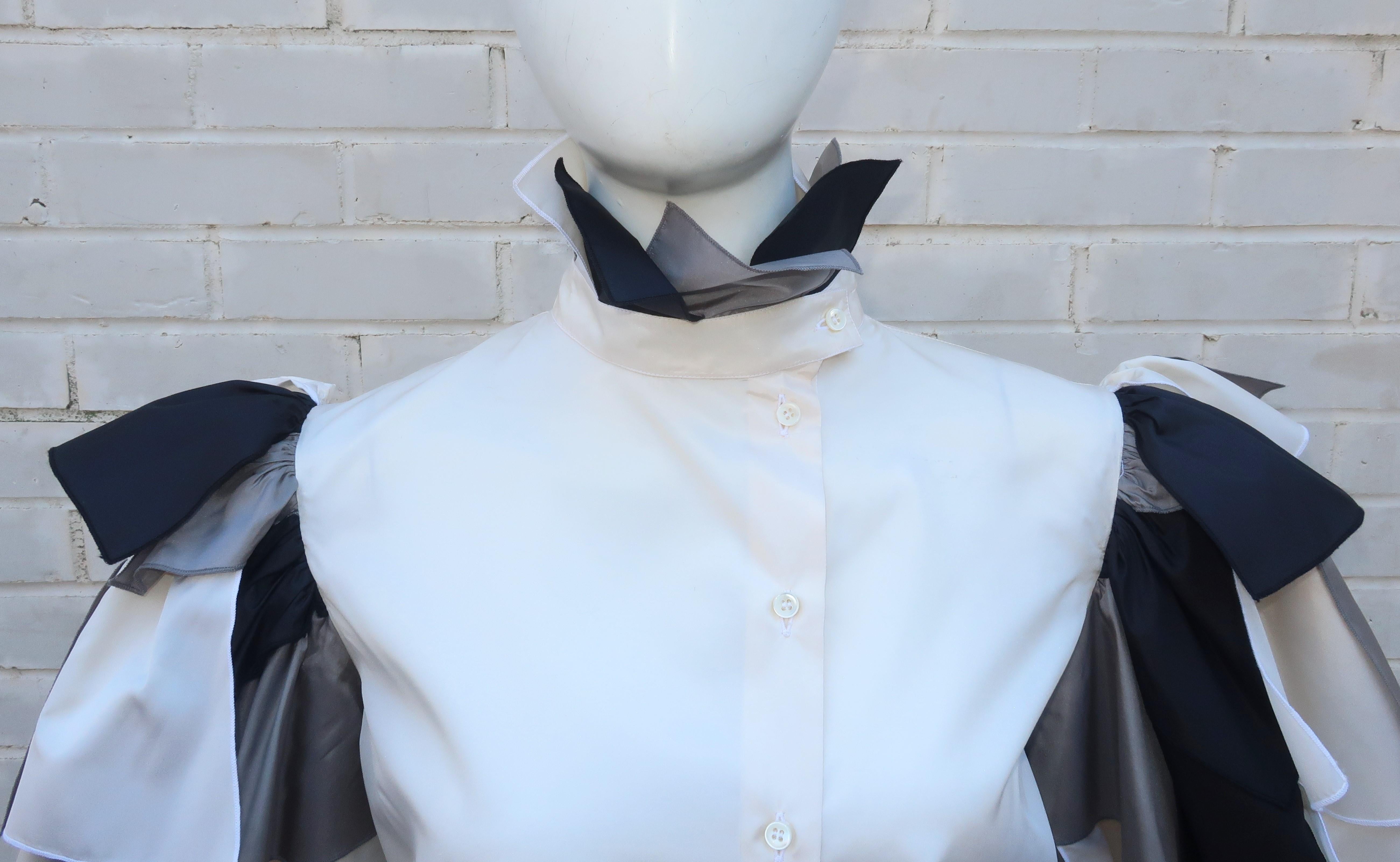 It is all about the sleeves with this adorable Italian silk taffeta blouse in shades of candlelight white, black and silvery gray.  The body of the blouse buttons up the front with an asymmetrical tab collar adorned with fabric swatches reminiscent