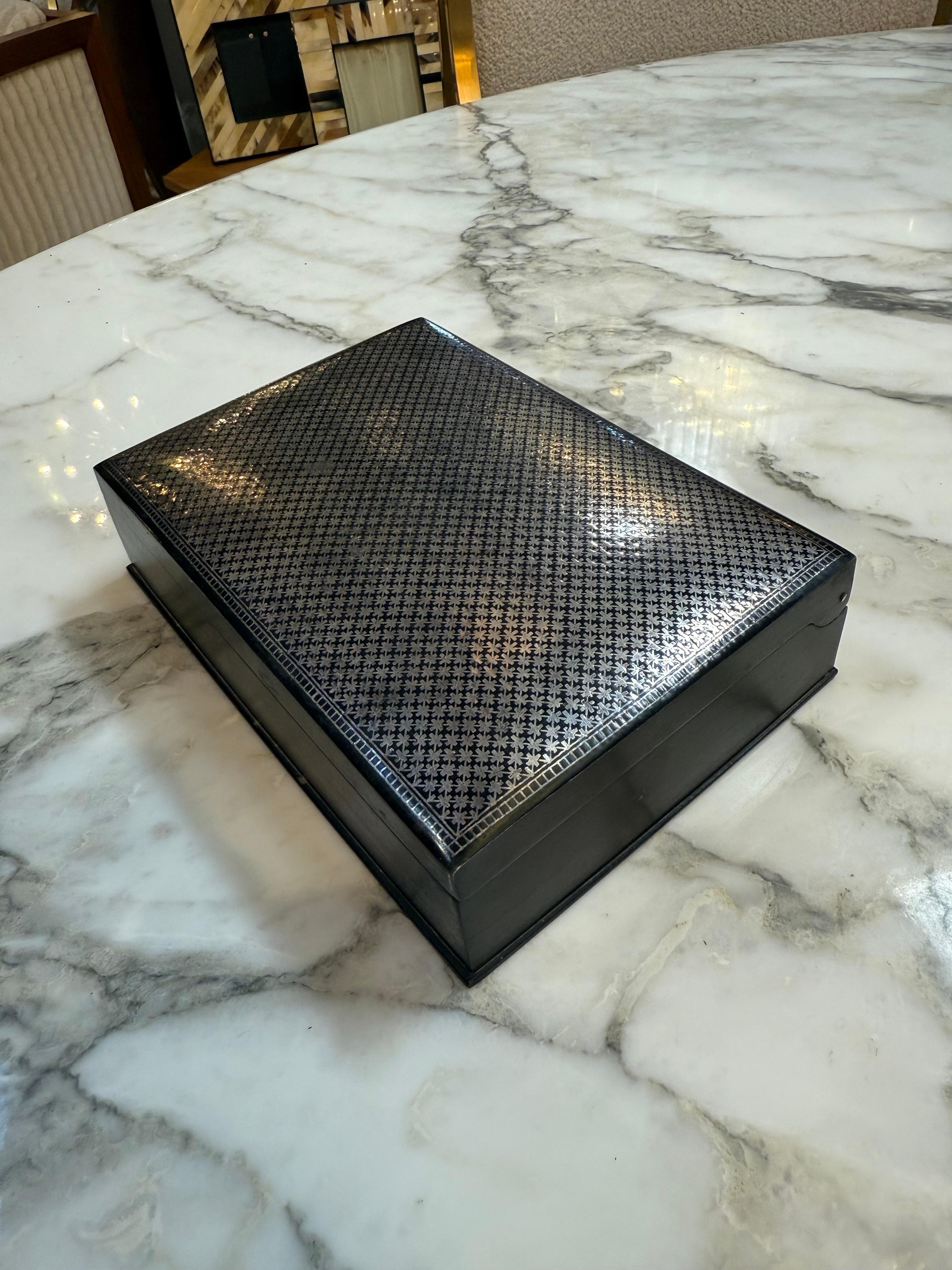 Scatola per carte da gioco italiana vintage, realizzata in metallo argentato con un raffinato motivo guilloché a tratteggio sul coperchio e intricati dettagli geometrici sul bordo. La scatola presenta una finitura lucida e a specchio con una sottile