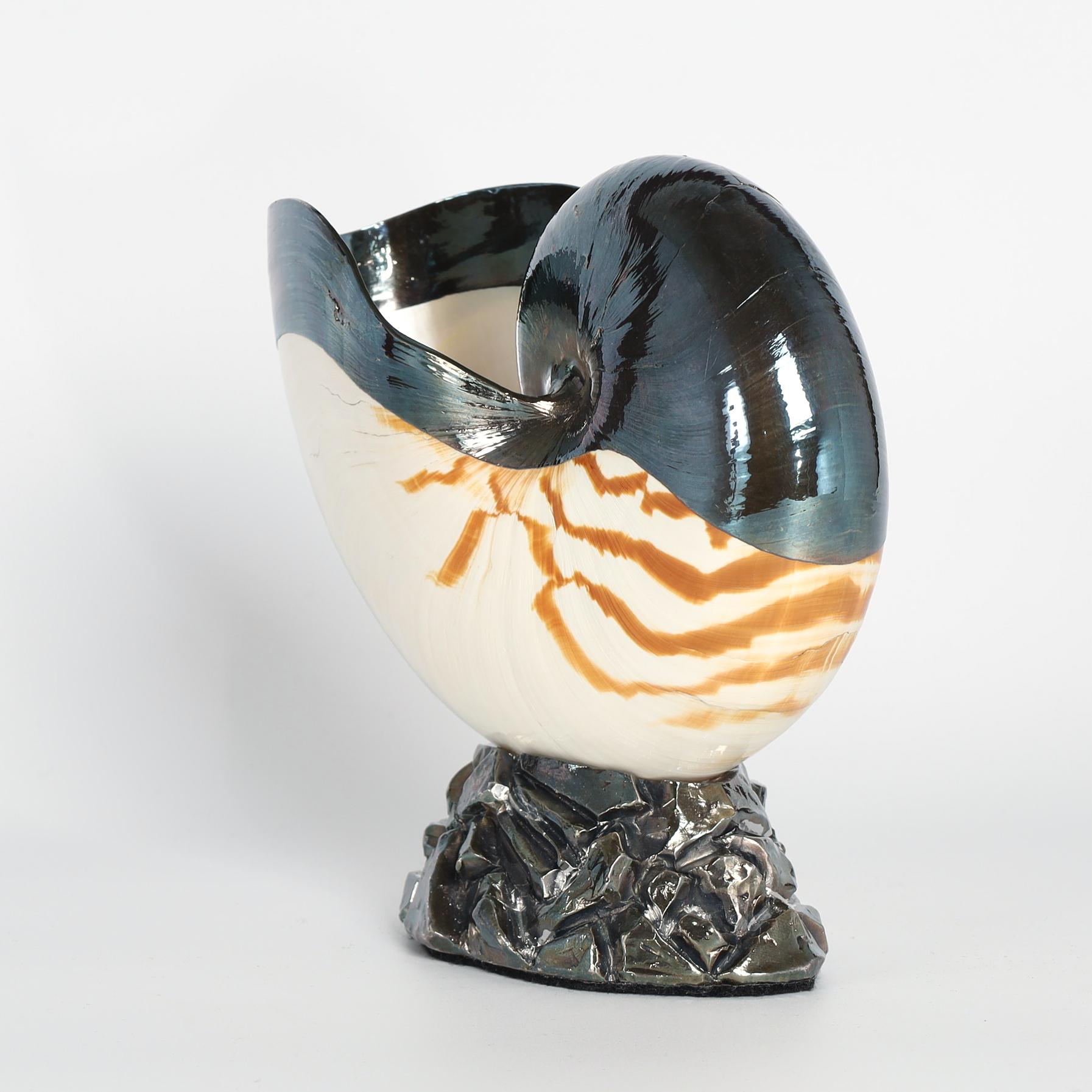Mid century Italian nautilus shell enhanced with silver plate overlay and presented on a silvered faux rock base. Signed Ruzzetti & Gow on the bottom. 