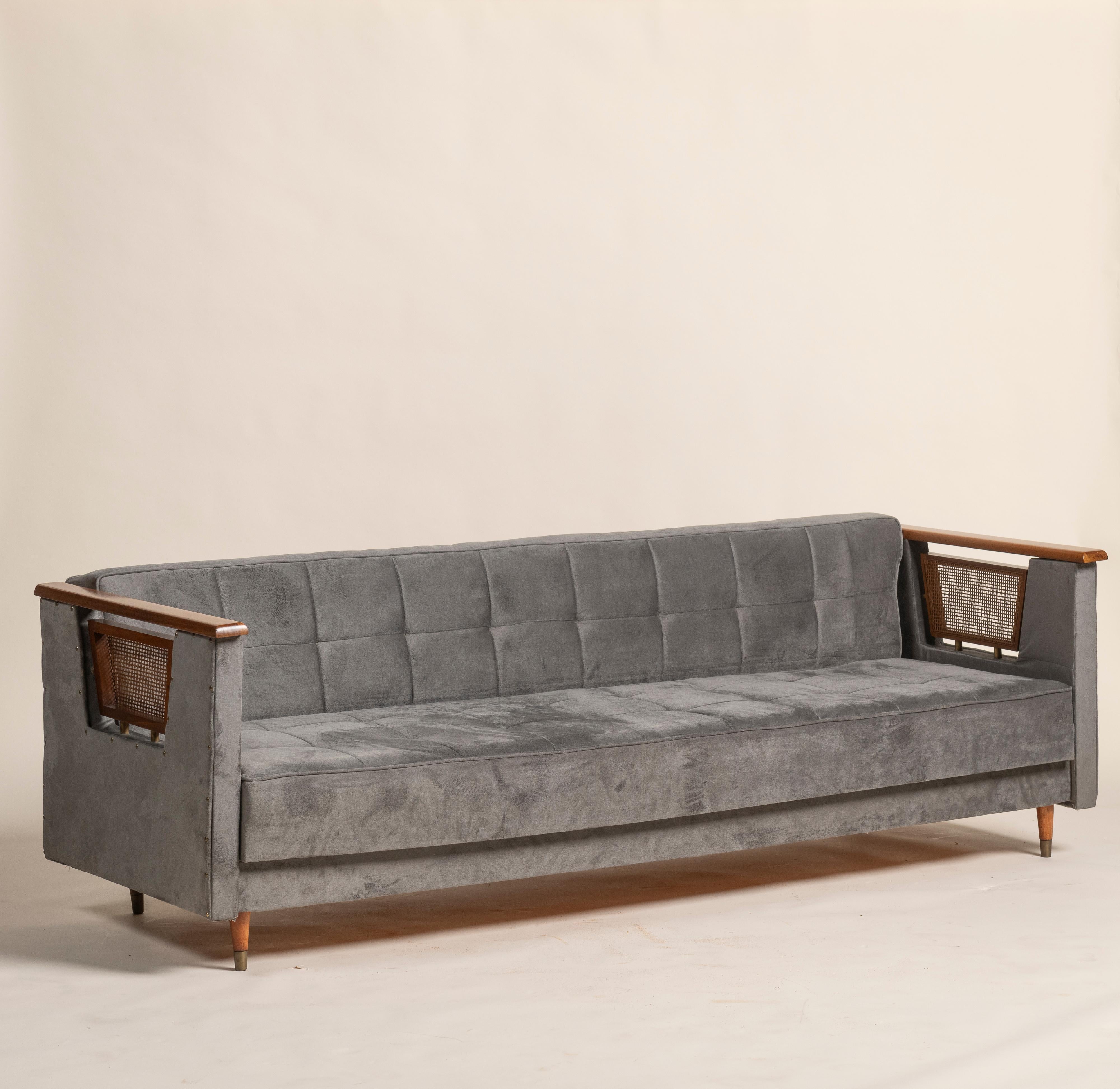 Rare canapé-lit italien vintage de 1950 au design épuré et minimaliste. Le meuble est revêtu d'un tissu gris cossu avec un dossier touffeté.  Les accoudoirs présentent une combinaison de bois et de panneaux cannelés, ce qui ajoute au style du milieu