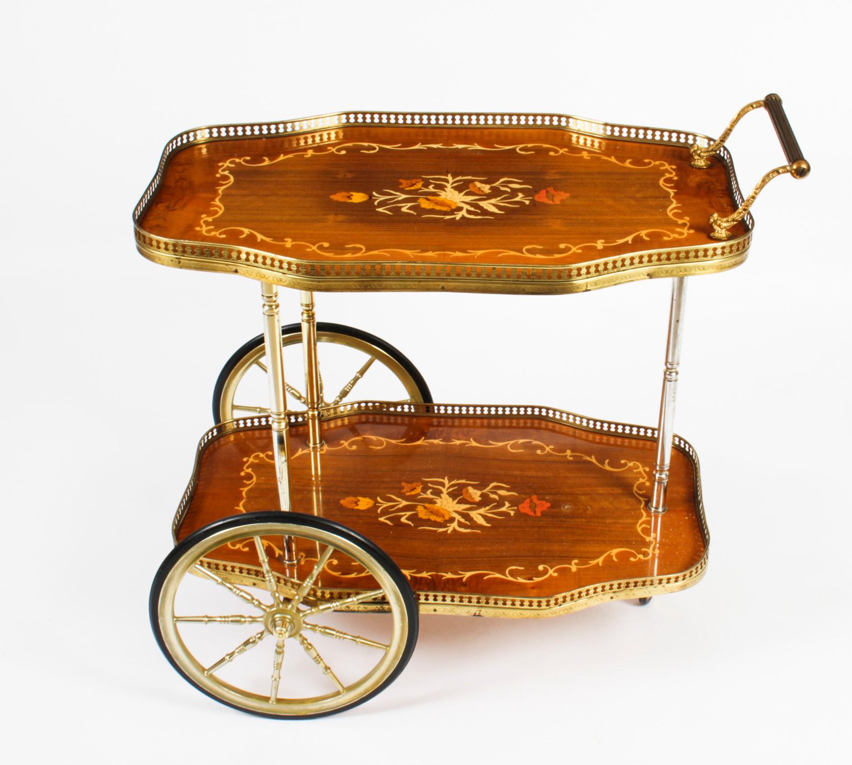 This is a very entertaining vintage mid century Italian Sorrento drinks trolley.

The two tier trolley is very decorative, with floral marquetry decoration, galleried ormolu borders, and handle.

Add some flair to your entertaining experience