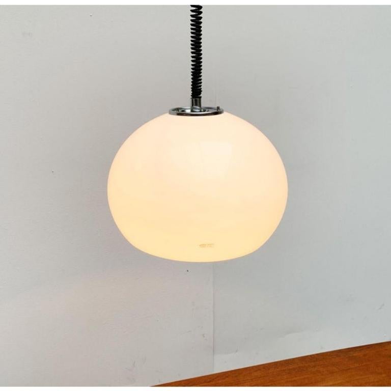 Lampe suspendue de Guzzini d'après un design de Luigi Massoni des années 60.

L'abat-jour caractéristique en plastique est réalisé en blanc translucide. Les éléments chromés sur le dessus et à l'intérieur sont remarquables. Cette pièce porte une