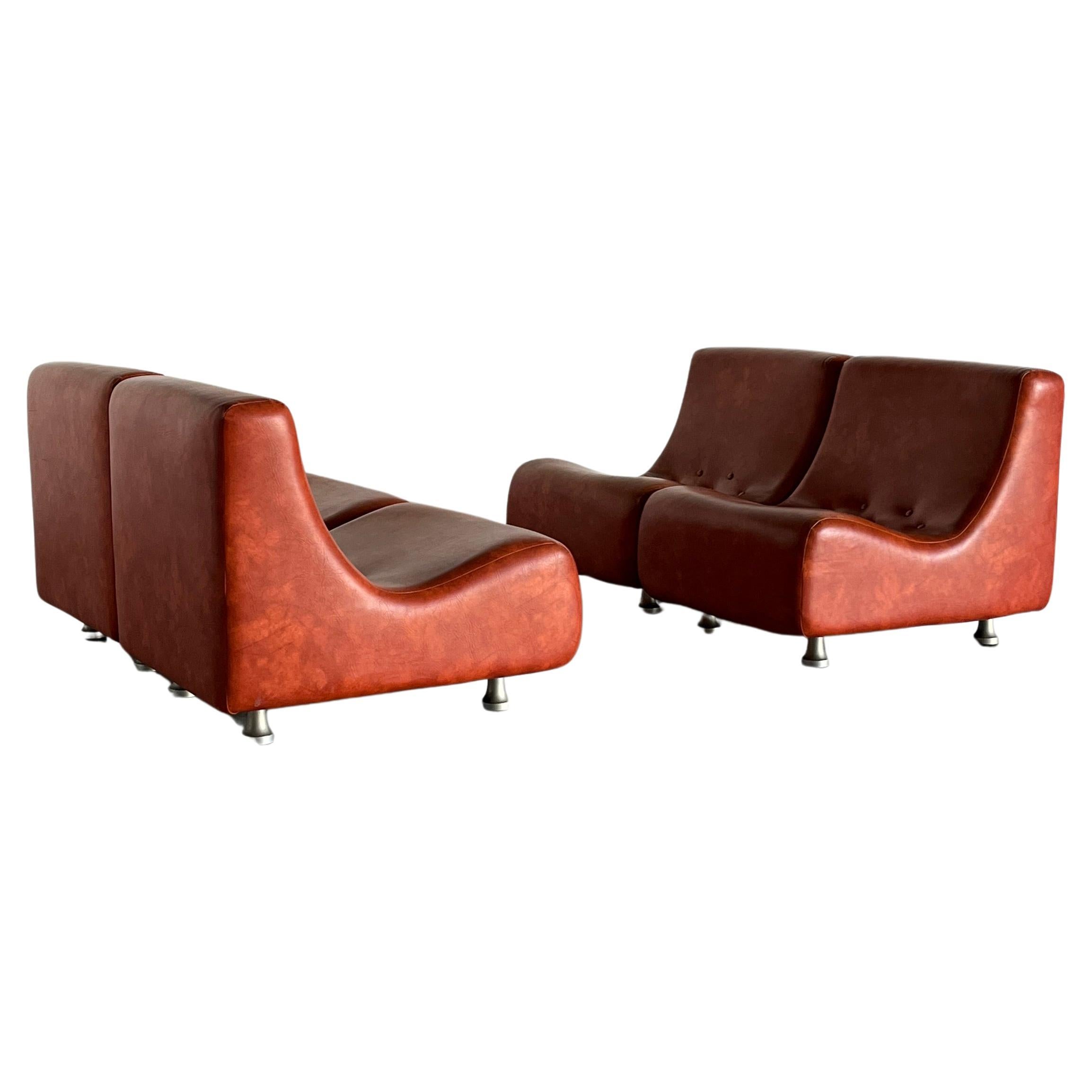 Ensemble de sièges de salon ou canapé modulaire italien Space-age en quatre parties. 
Une forme magnifique et unique et une production de haute qualité des années 1970 dans un épais revêtement en similicuir brun rougeâtre.
Dans le style des designs