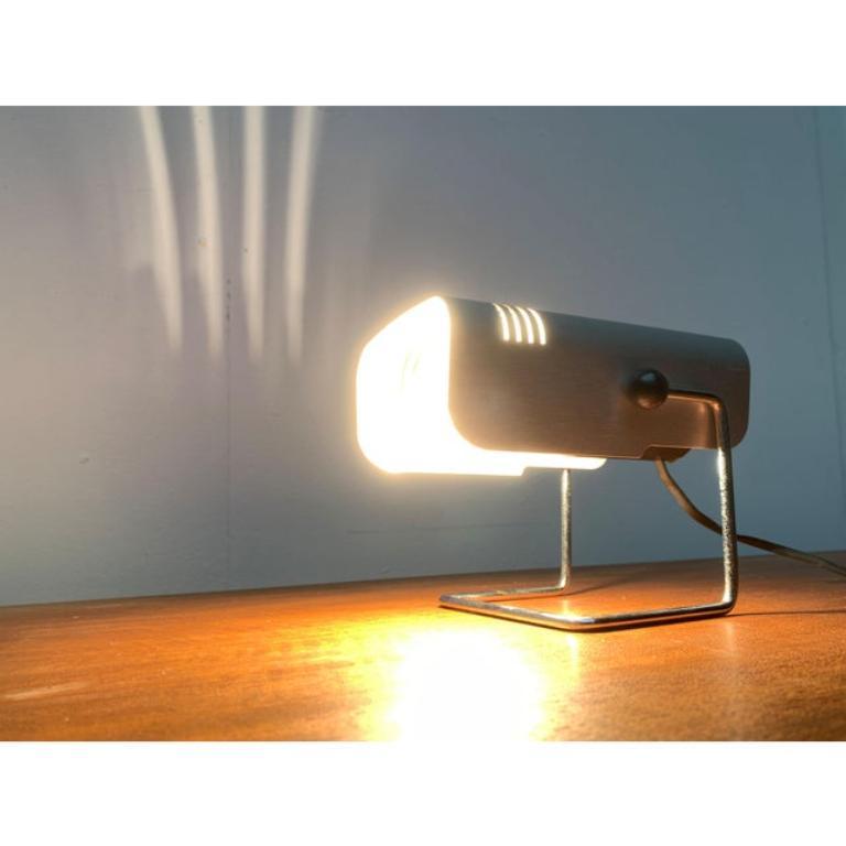 Rares lampes de table de l'ère spatiale du fabricant italien Targetti.

Ce petit Luminaire agit comme un petit personnage. Il se compose presque entièrement de l'écran réflecteur constitué d'une feuille de métal sculptée. Le pied forme une simple