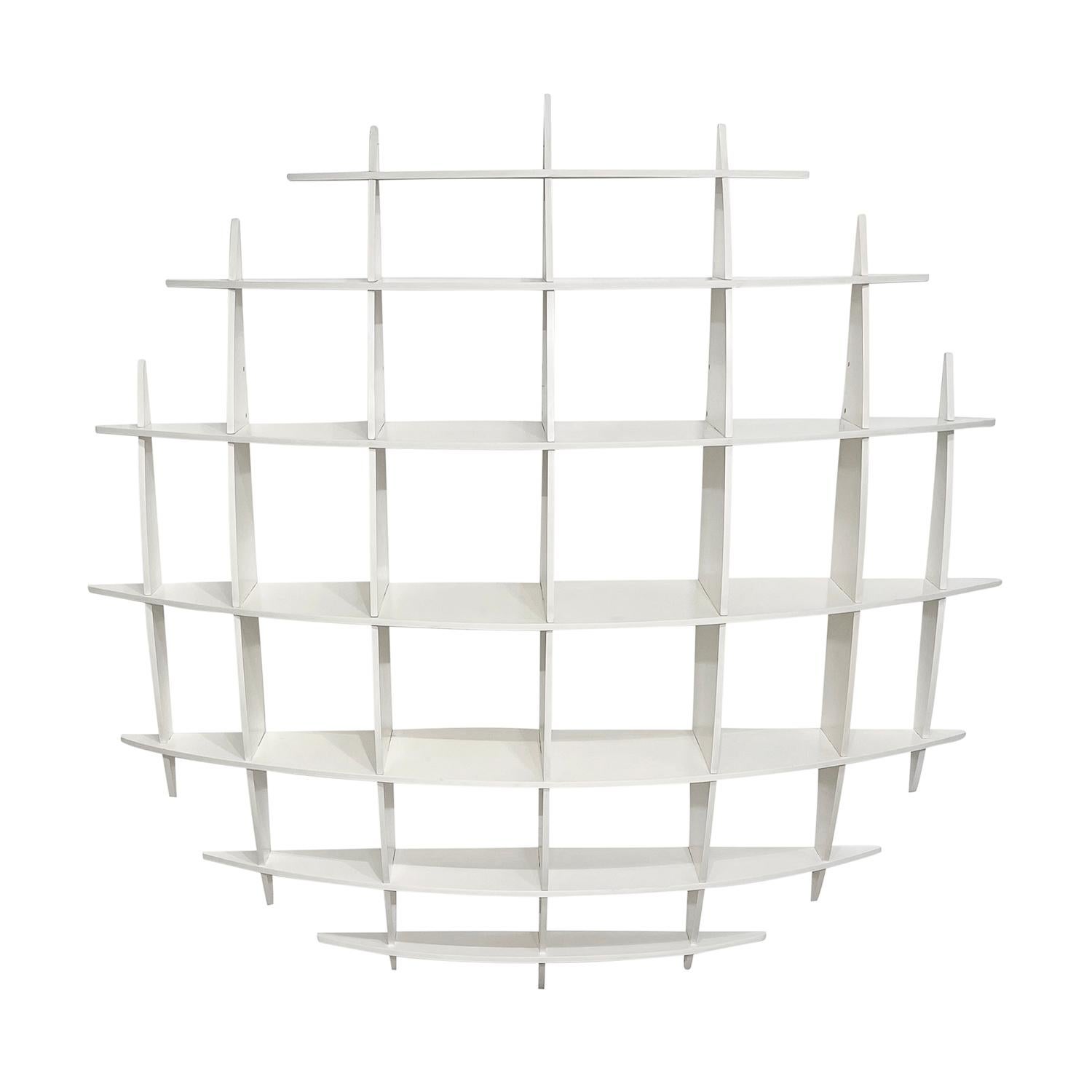 A large, white vintage Mid-Century modern Italian bookcase made of hand crafted lacquered Pinewood designed by Manfredo Massironi for Nikol International, in good condition. The library shelf imitates a sphere grid protruding from the wall. It is