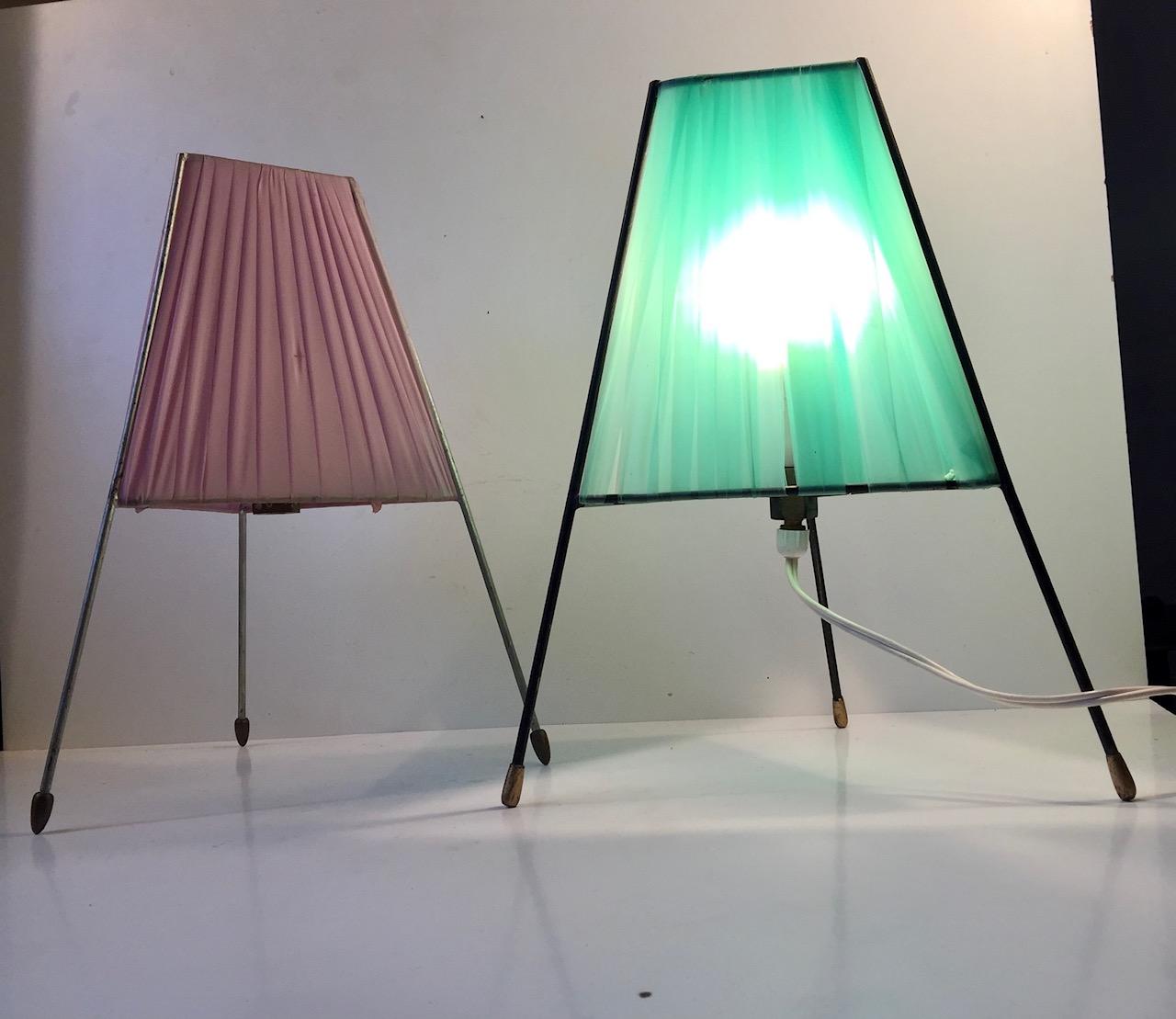 A set of Sputnik table lights with steel frames, brass feet and light green and pink acrylic shading. Manufactured and designed anonymously in Italy during the 1950s in a style reminiscent of Stilnovo. Both of them will be shipped in working