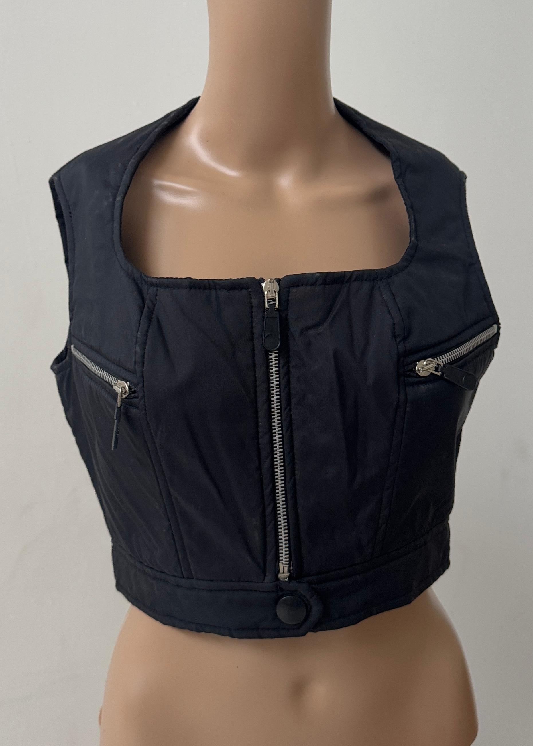 Pièce rare et frappante de la fin du XXe siècle, ce top vintage cropped met en valeur l'esthétique audacieuse et structurée qui a défini les modèles les plus avant-gardistes de l'époque. Confectionné en Italie, il associe des influences utilitaires