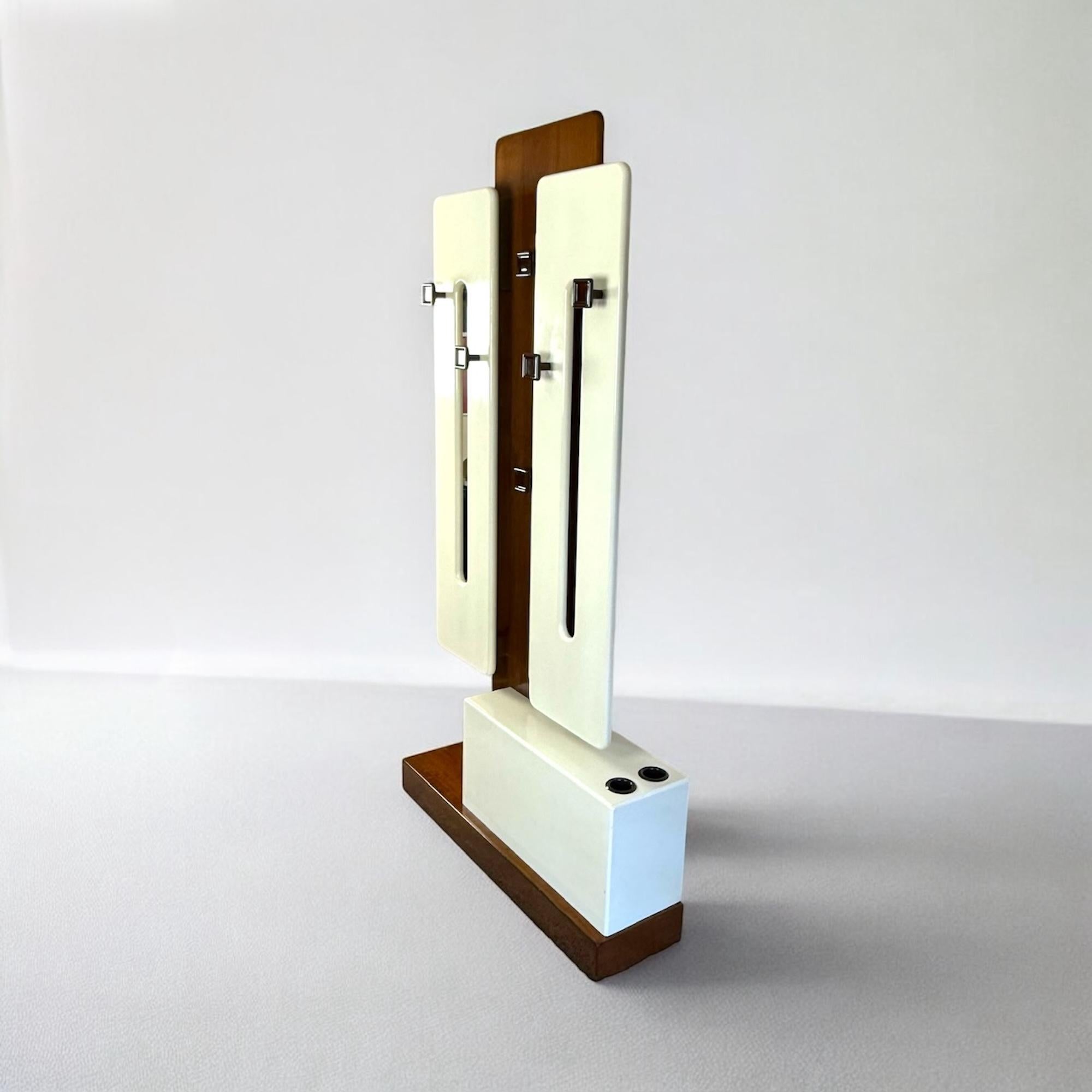 Beautiful and rare free standing coat rack designed  and manufactured in Italy in the 60s. This coat hanger features lacquered white wood panels that create a nice contrast with the walnut finish.

The bottom white box has two compartments for