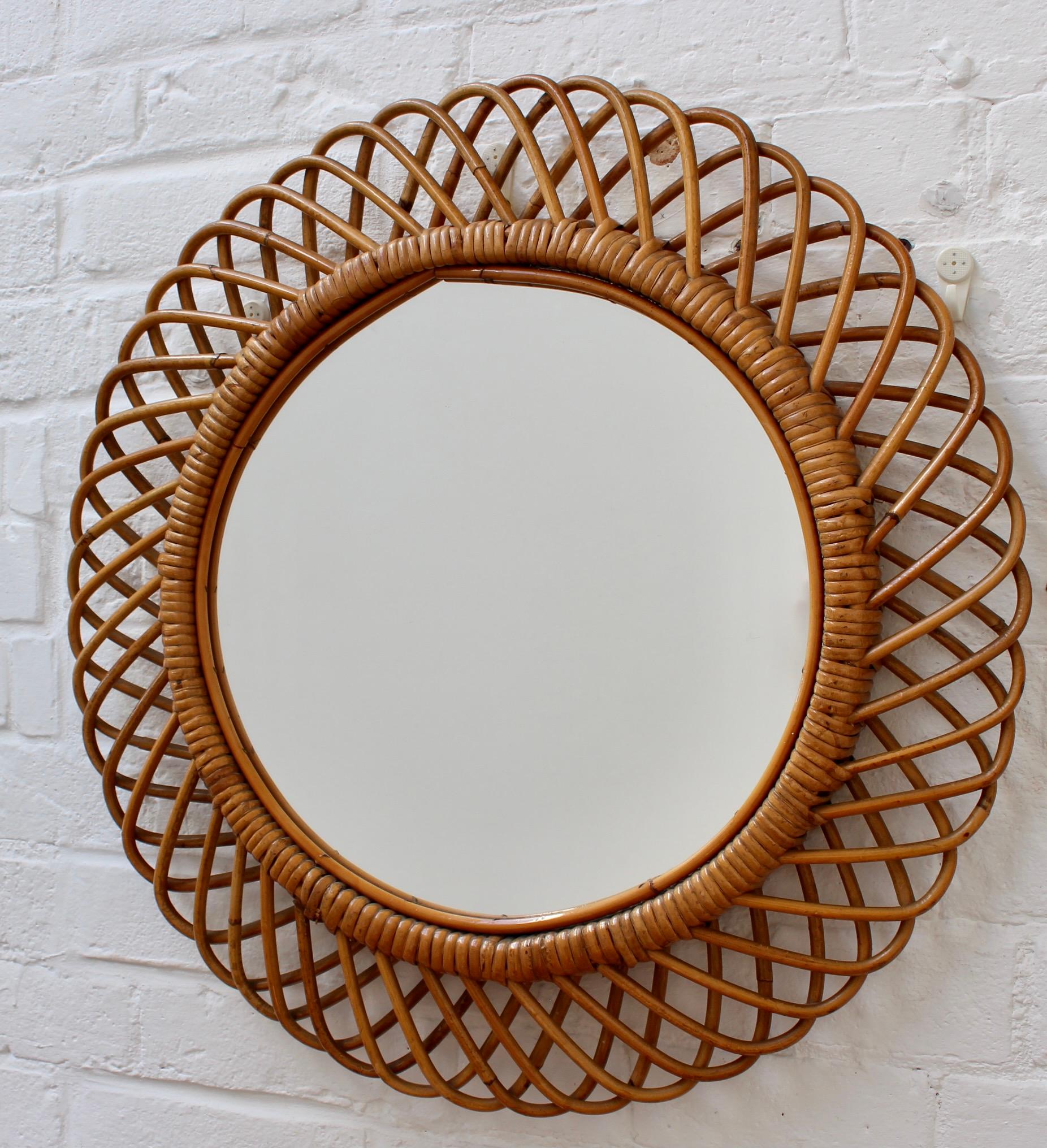 Italian round rattan wall mirror (circa 1960s). A Mid-Century mirror with a very delightful sunburst motif created by a series of rattan horseshoe-shaped 'sunbeams' bound together. There is a characterful, aged patina on the mirror frame. In good