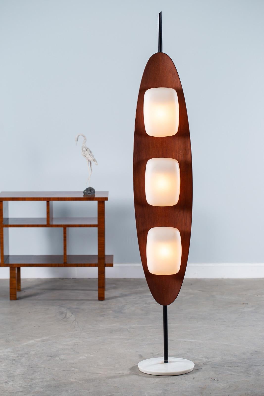 A cool vintage Italian teak wood surfboard floor lamp by Goffredo Reggiani, circa 1970. This rare Reggiani lamp showcases the international fascination with California surf culture that swept the world beginning in the 1960s. The circular solid