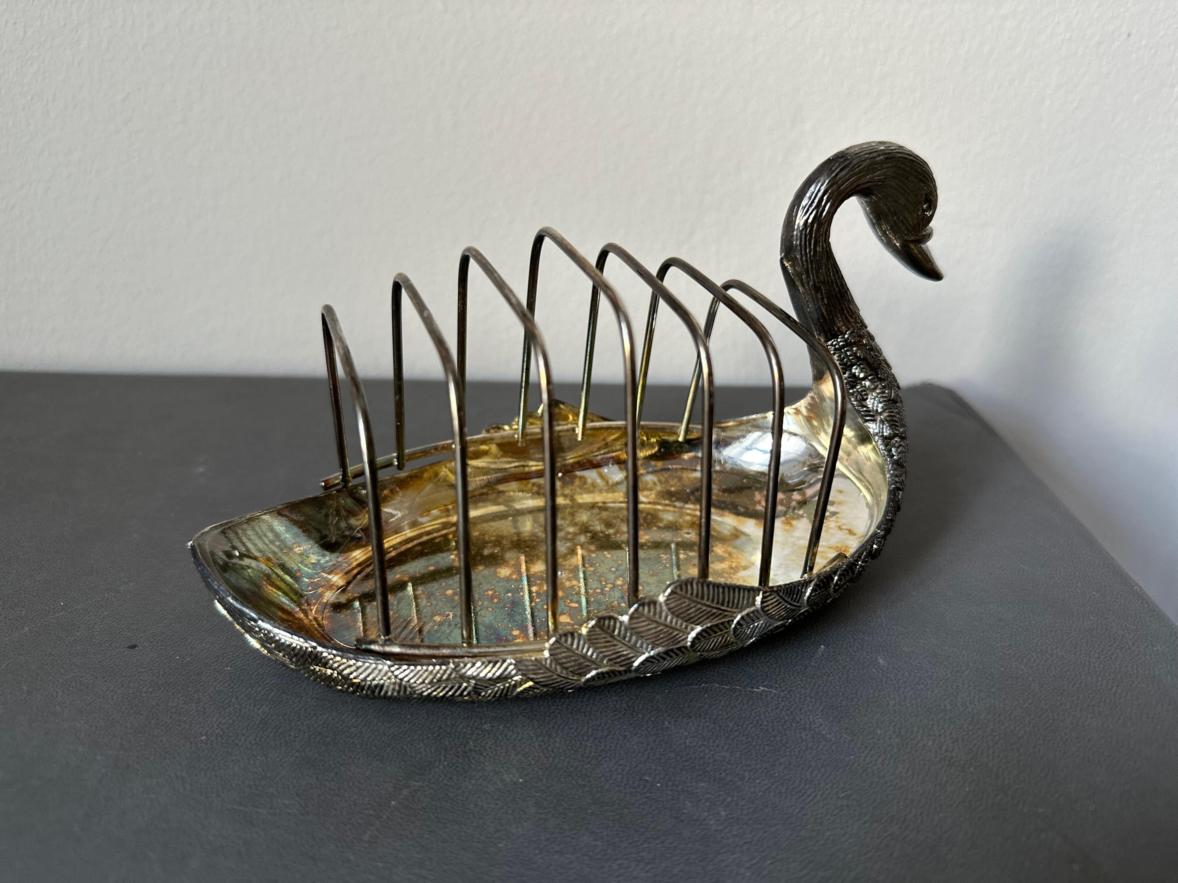 This exquisite vintage toast rack, designed in the shape of a graceful swan, was crafted in Italy in the 1970s. Made from silver-plated metal, it features a delightful blend of elegance and whimsy. The surface has developed a charming patina over