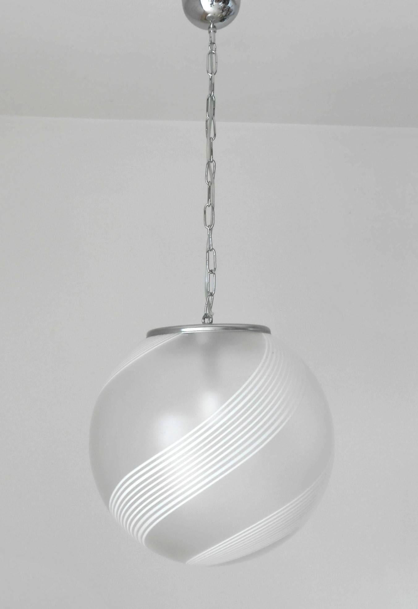 Vintage Italian pendant with frosted Murano glass globe with hand blown white Murano glass stripes, mounted on chrome hardware / Designed by Venini circa 1960s / Made in Italy 1 light / E26 or E27 type / max 60W
Measures: diameter: 16 inches /