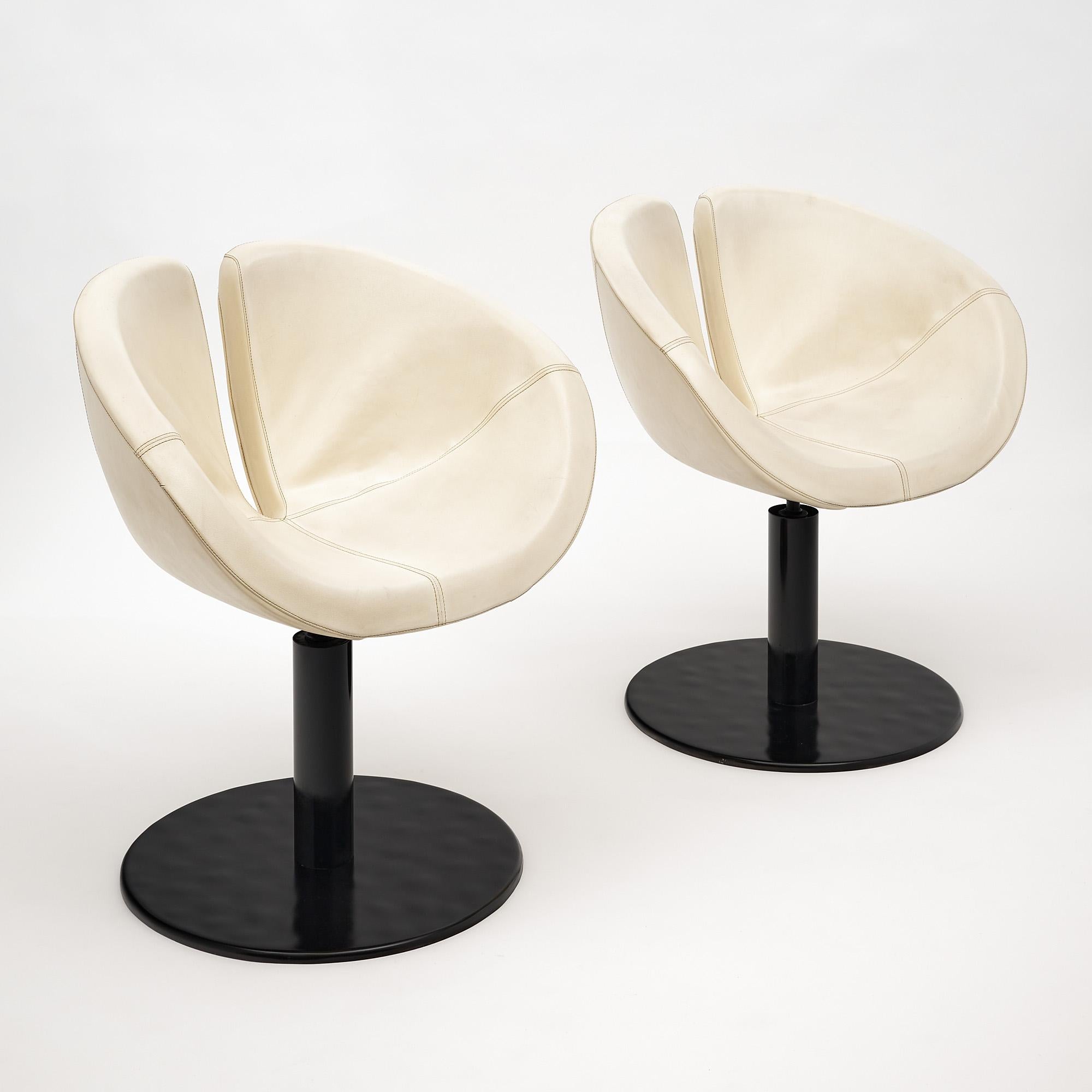 Pair of swiveling armchairs, Italian, with the original ivory vinyl upholstery and lacquered steel base.