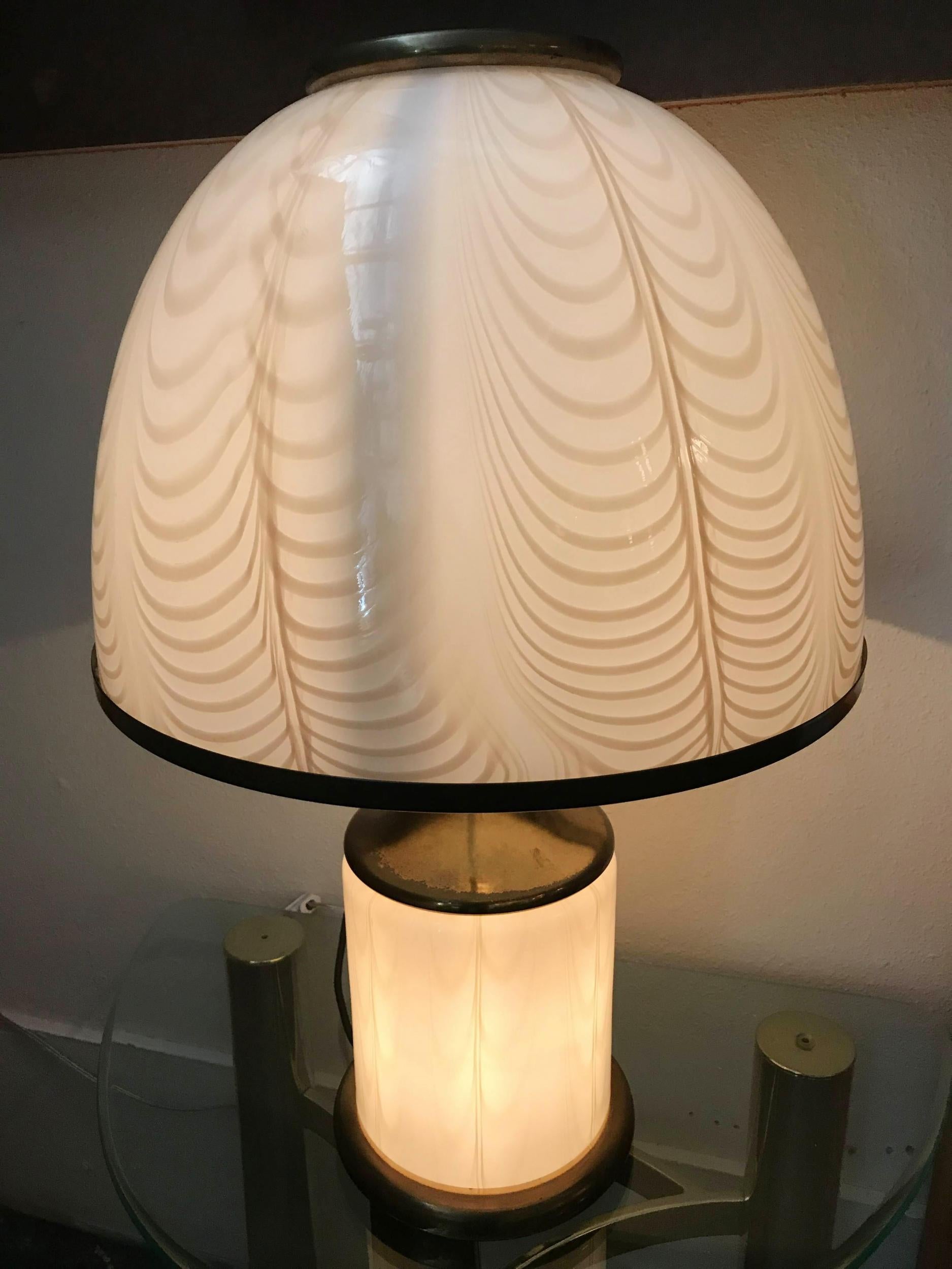 Italian vintage table lamp with cream colored Murano glass decorated with amber feather-shaped details on brass hardware, by F. Fabbian for Mazzega, made in Italy in the 1970s 

2-light / 1 in the shade and 1 in the base.